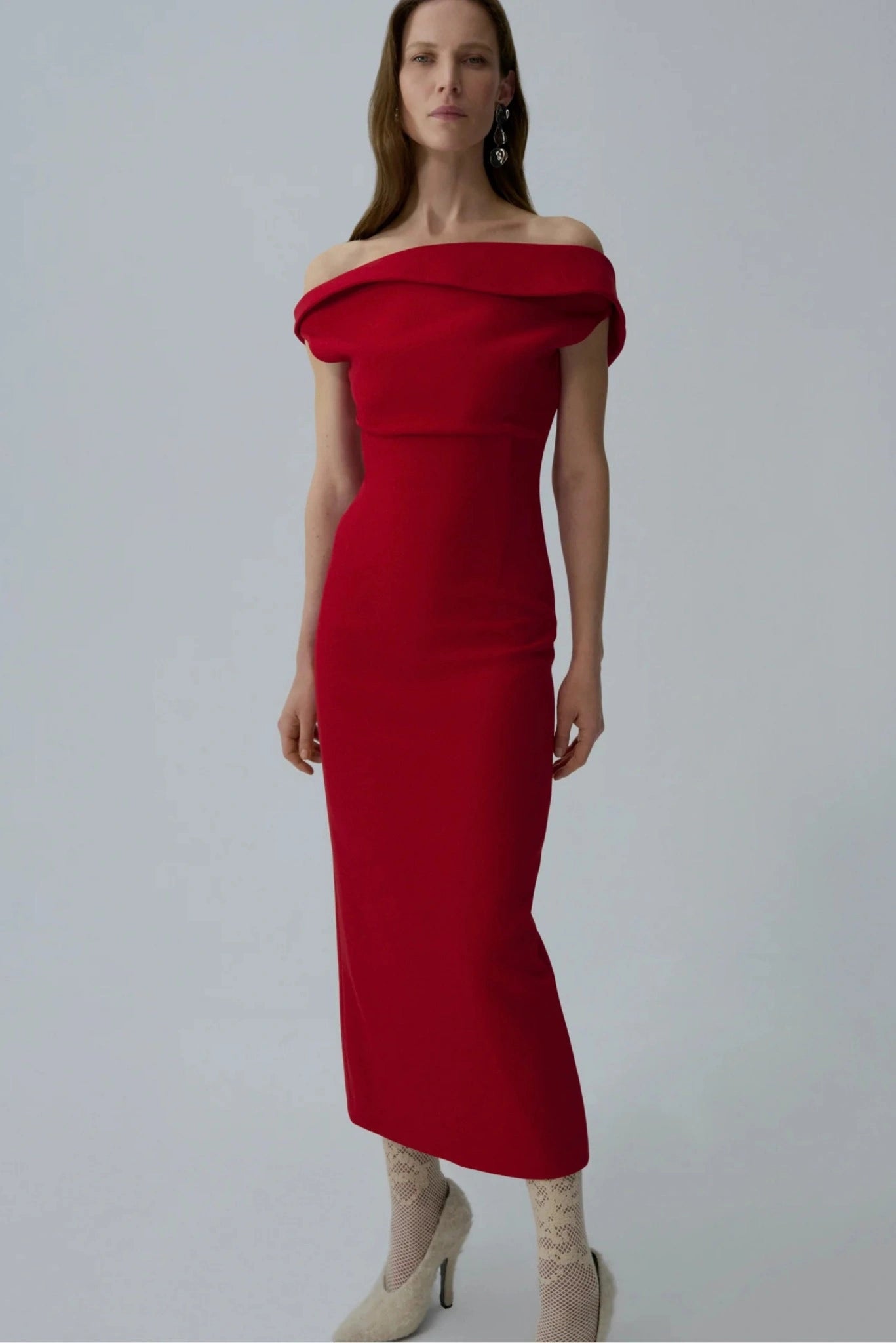 Modelo usando vestido midi vermelho Magda Butrym com decote ombro a ombro e caimento reto
