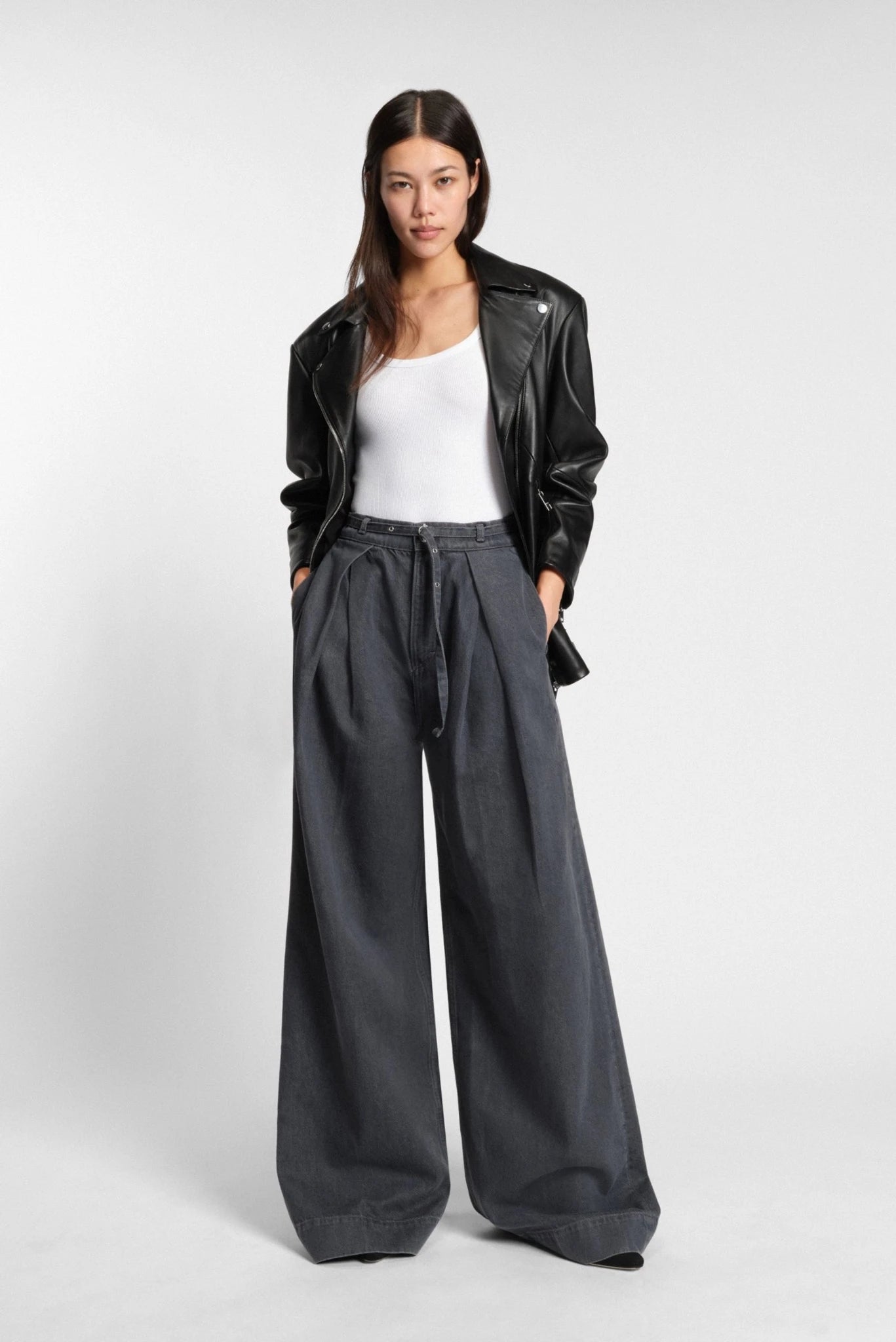Modelo usando jaqueta biker preta Hugo Boss em couro com zíper diagonal