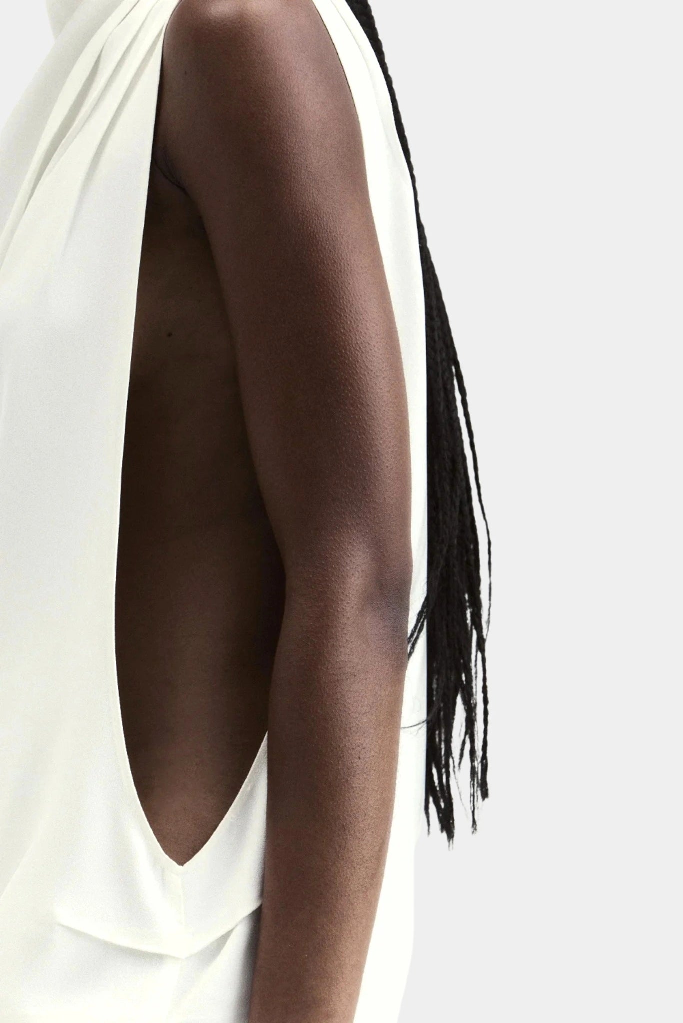 Detalhe lateral do vestido off-white com recorte profundo e caimento fluido
