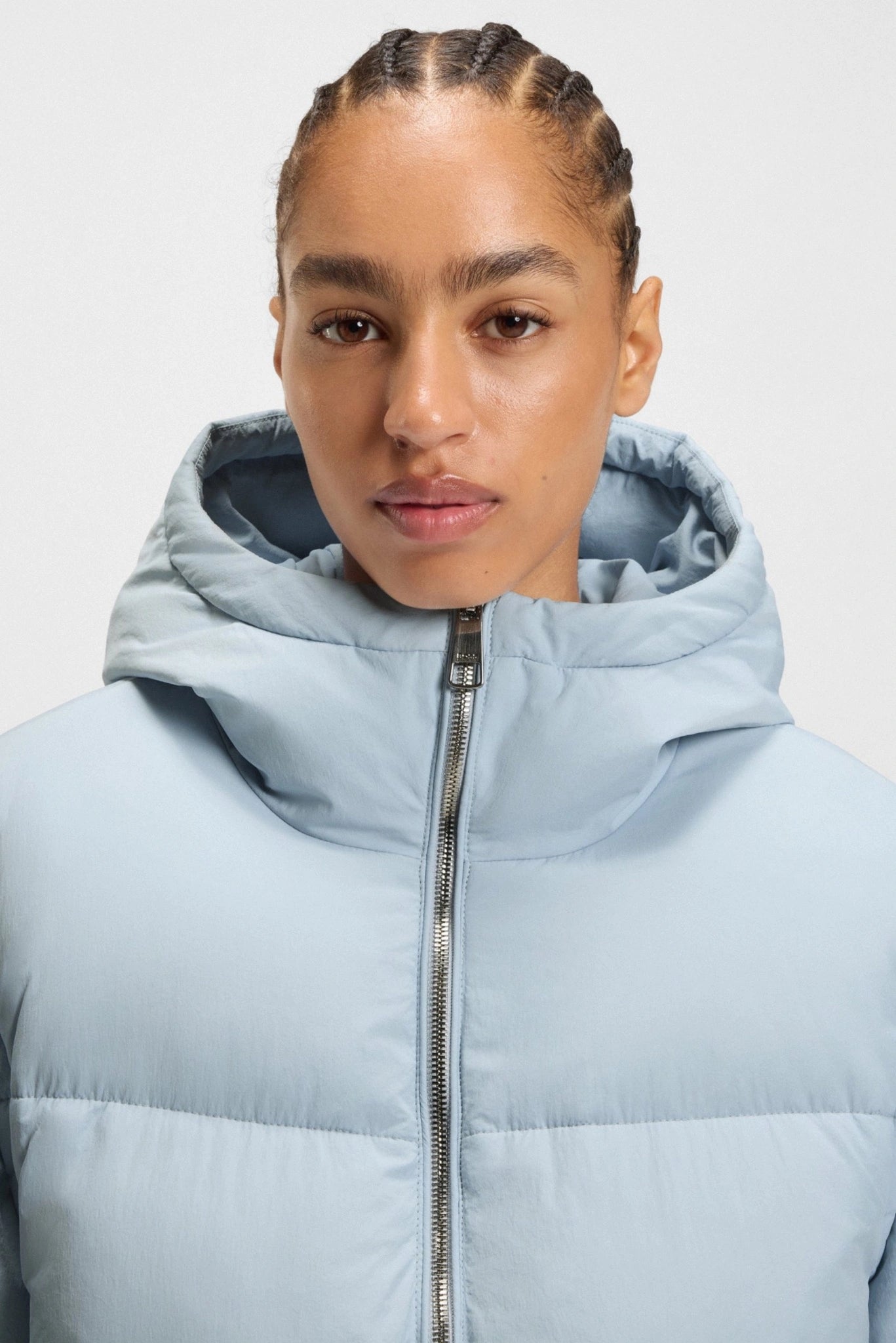 Close da jaqueta puffer azul-claro Hugo Boss com capuz e fechamento por zíper
