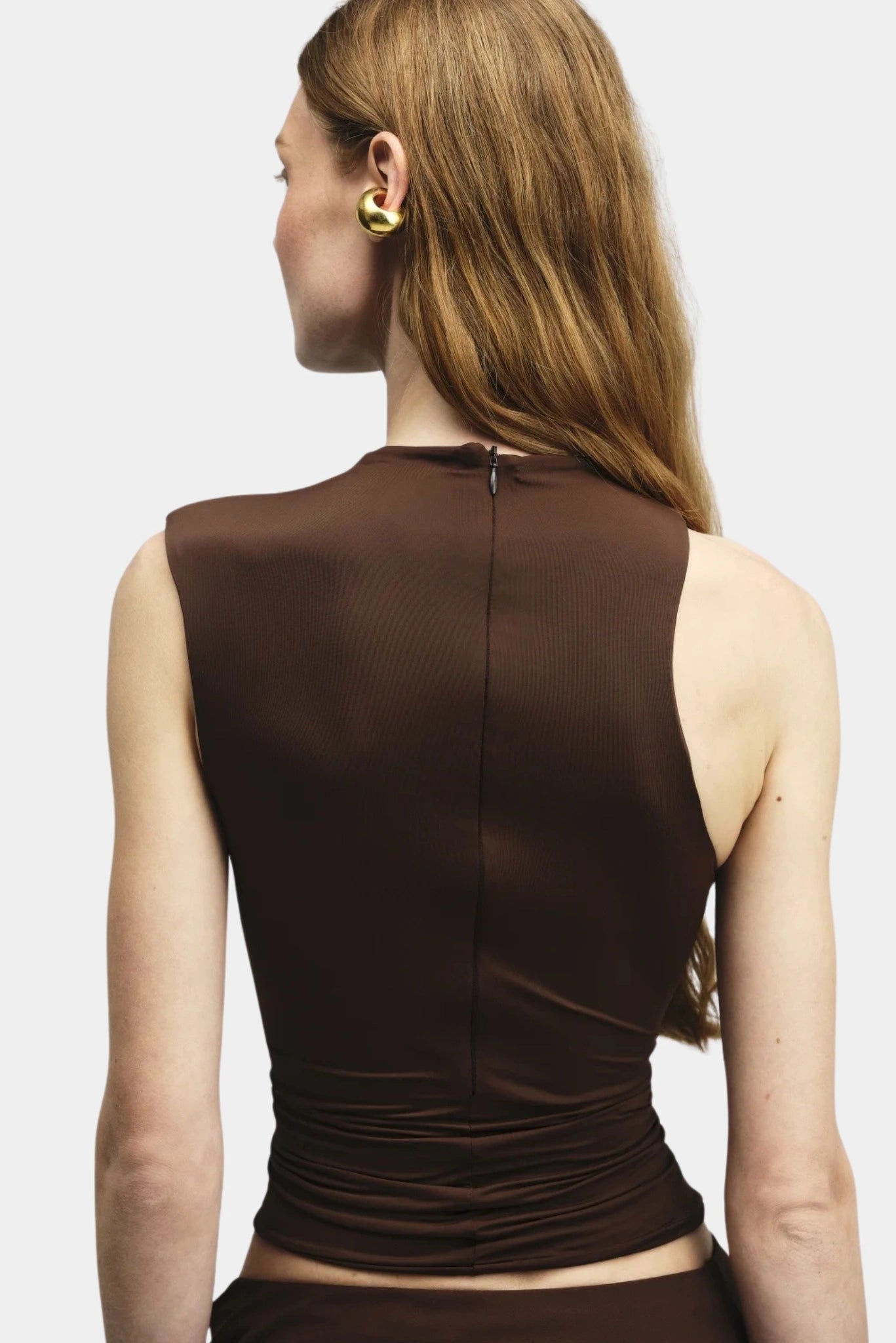Costas da blusa marrom sem mangas com fechamento posterior e gola alta