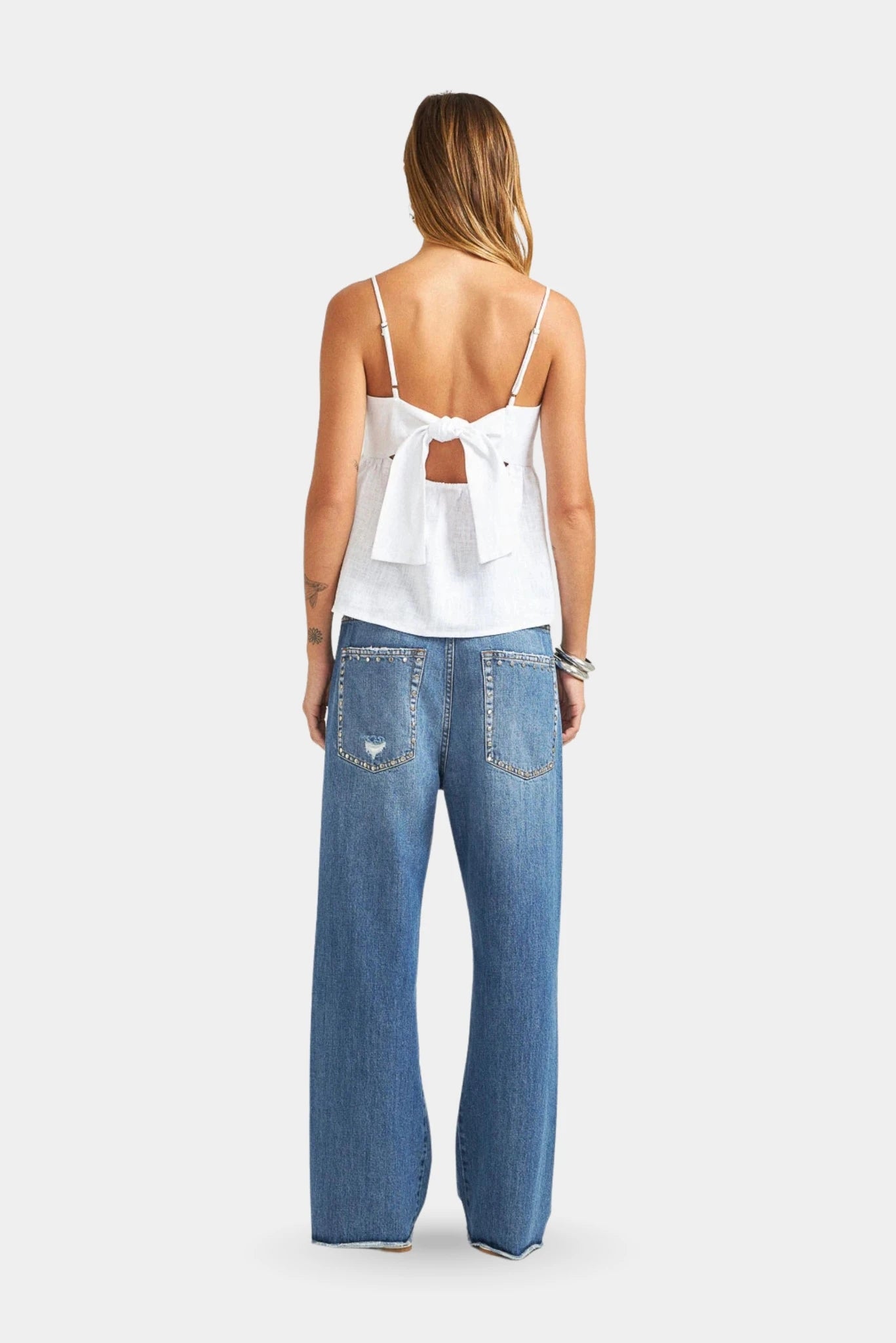 Calça Loose Cropped Tachas L•Dnim em denim azul com bolsos traseiros e detalhes metálicos