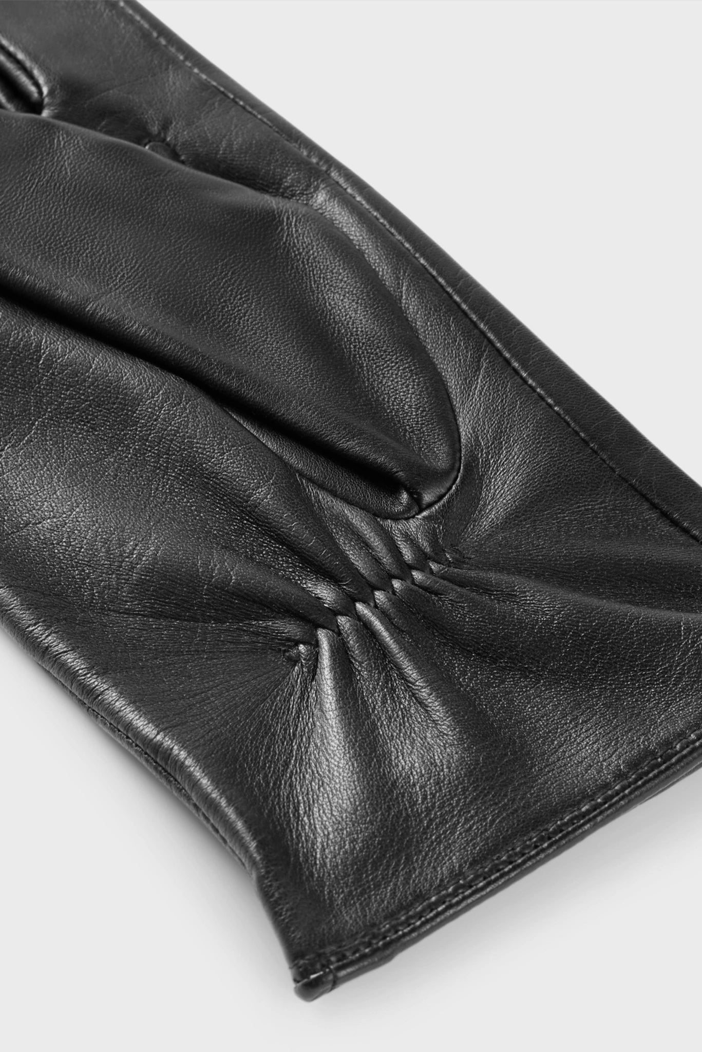Detalhe interno da luva de couro preta Hugo Boss com pregas no punho