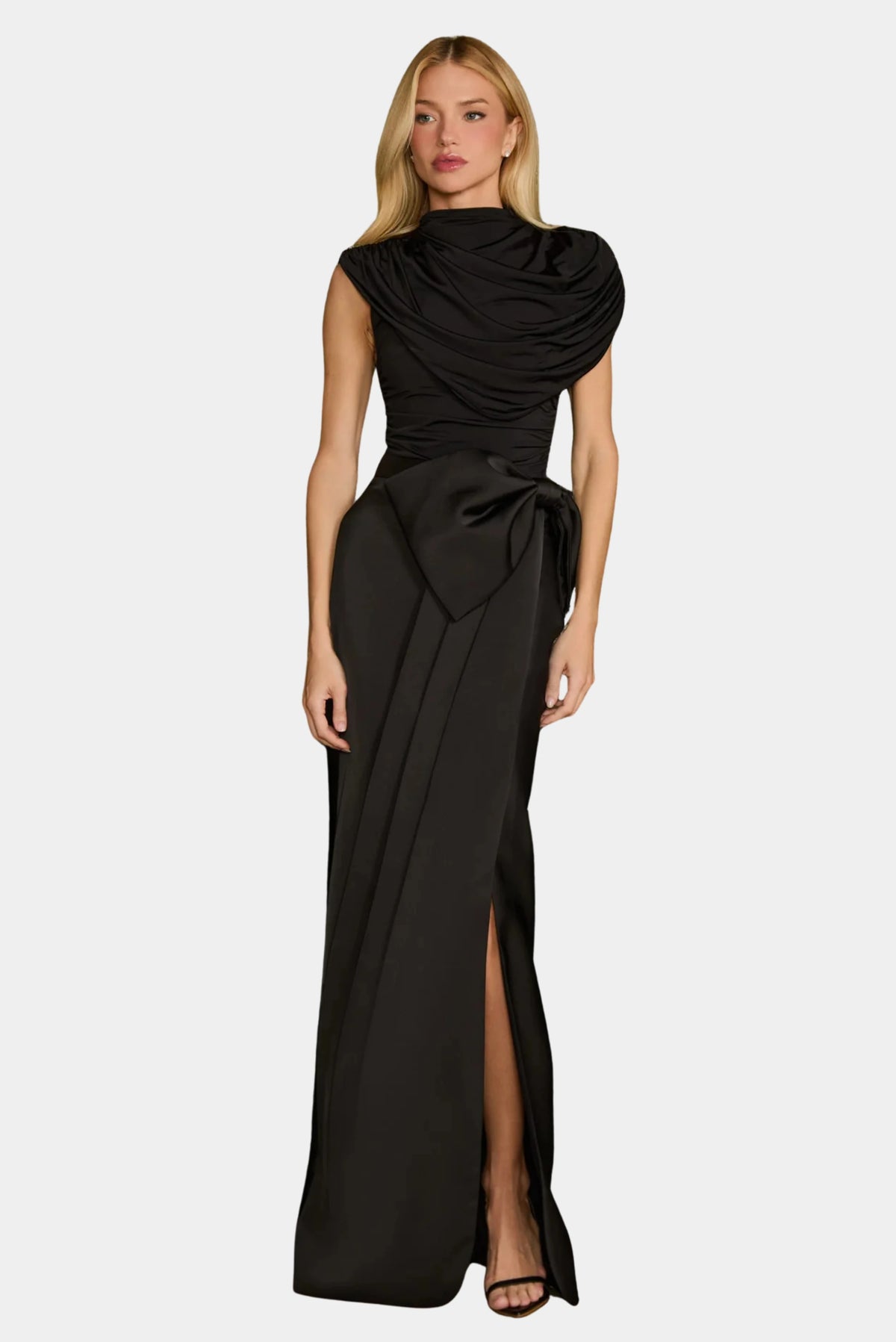 Modelo usando Saia Longa Nicole em cetim preto com laço oversized e transpasse frontal.