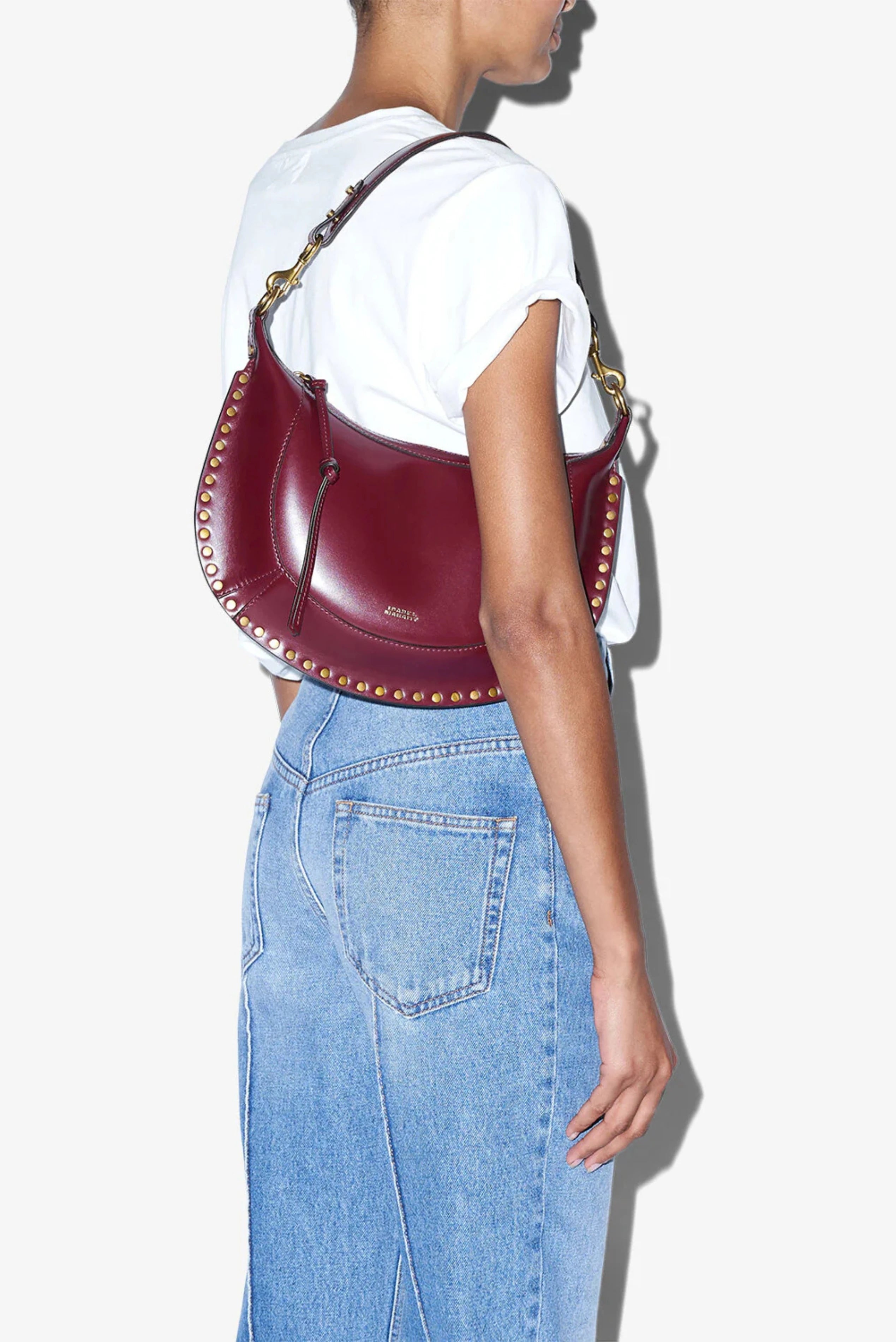 Bolsa Naoko Isabel Marant em couro bordô com formato meia-lua e tachas douradas
