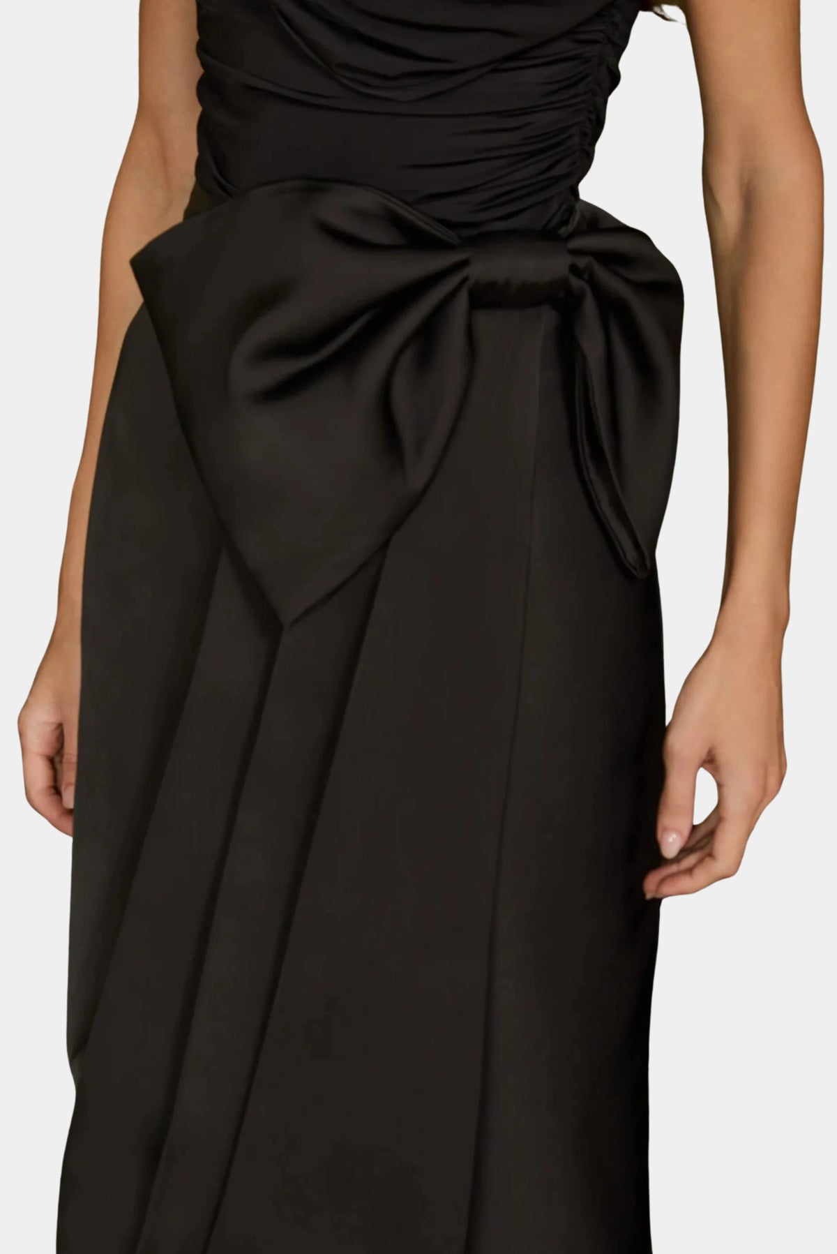 Detalhe do laço oversized na cintura da Saia Longa Nicole em cetim preto.