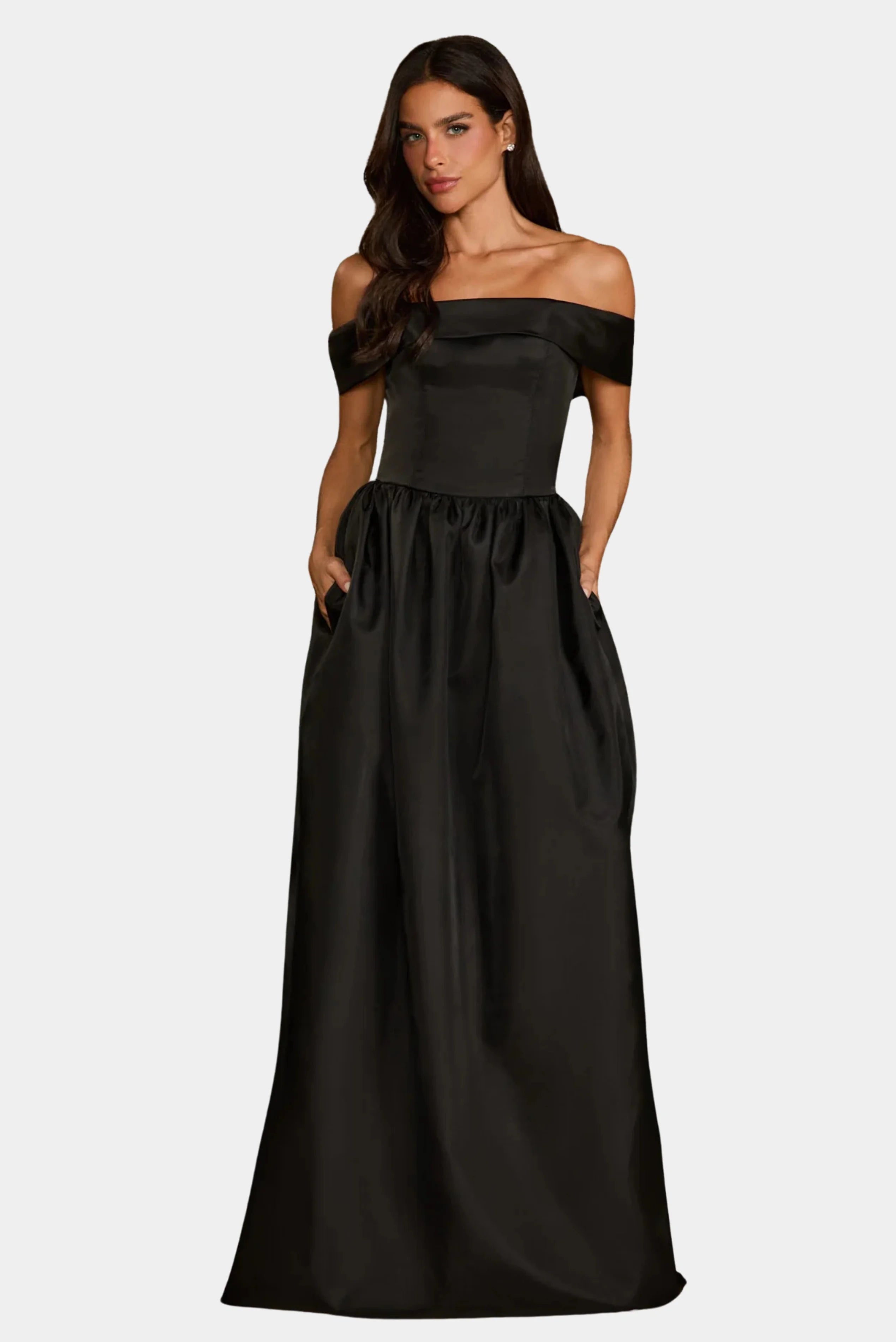 Modelo usando vestido longo preto Giulia Fabulous em tafetá com decote ombro a ombro e bolsos laterais