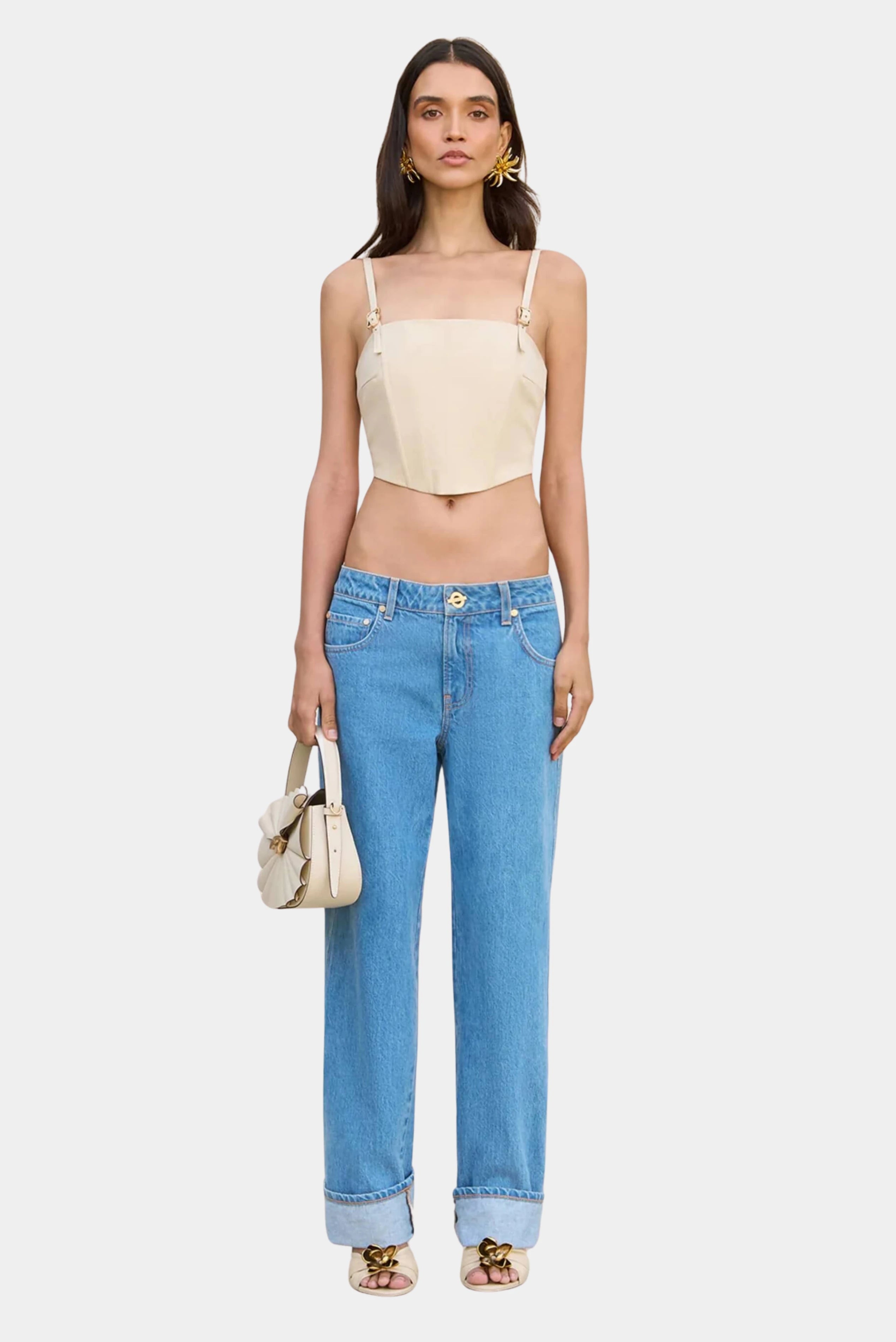 Top cropped bege Cult Gaia com alças finas ajustáveis e calça jeans reta
