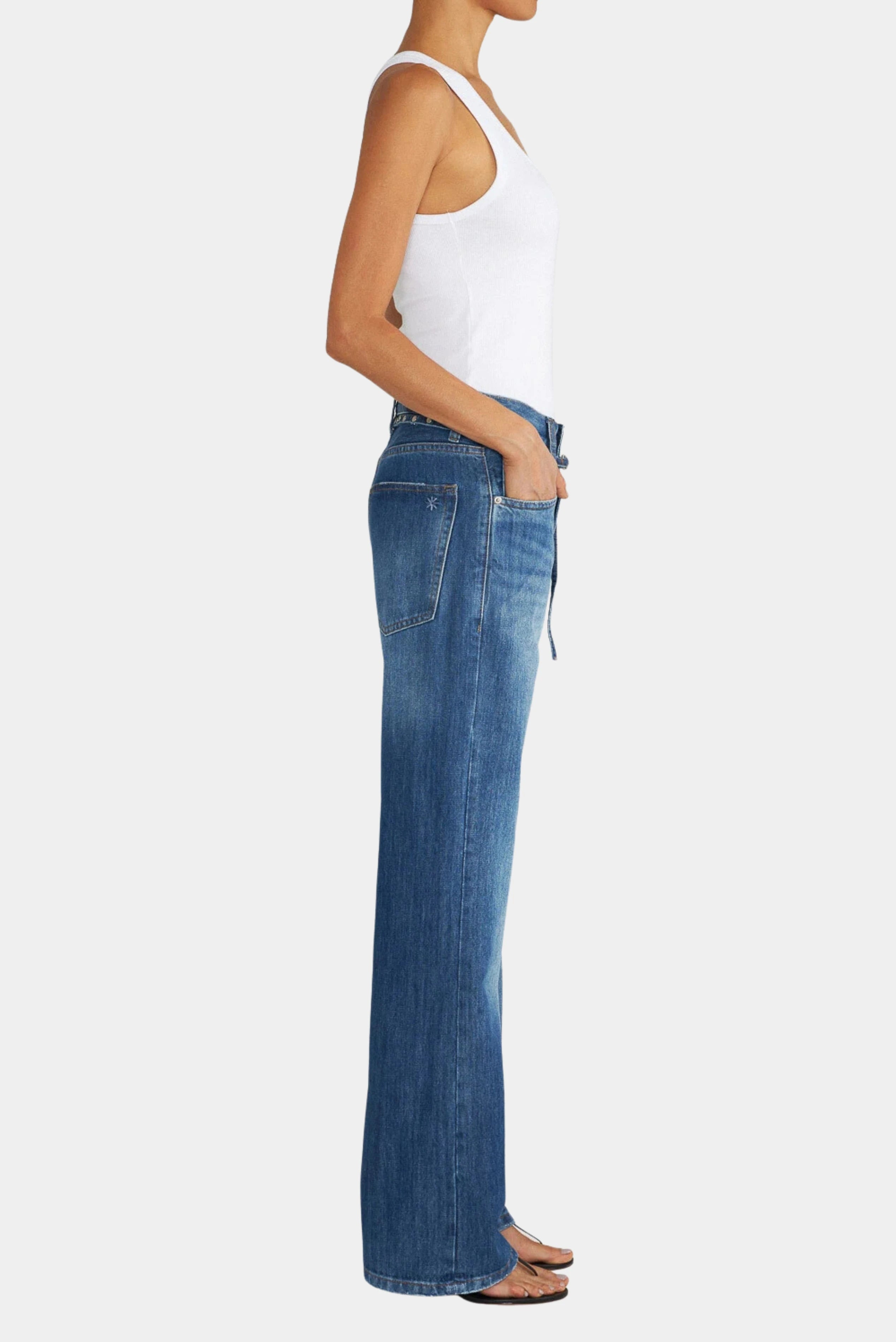 Vista lateral da calça jeans loose azul de cintura alta com pernas amplas e bolsos frontais.