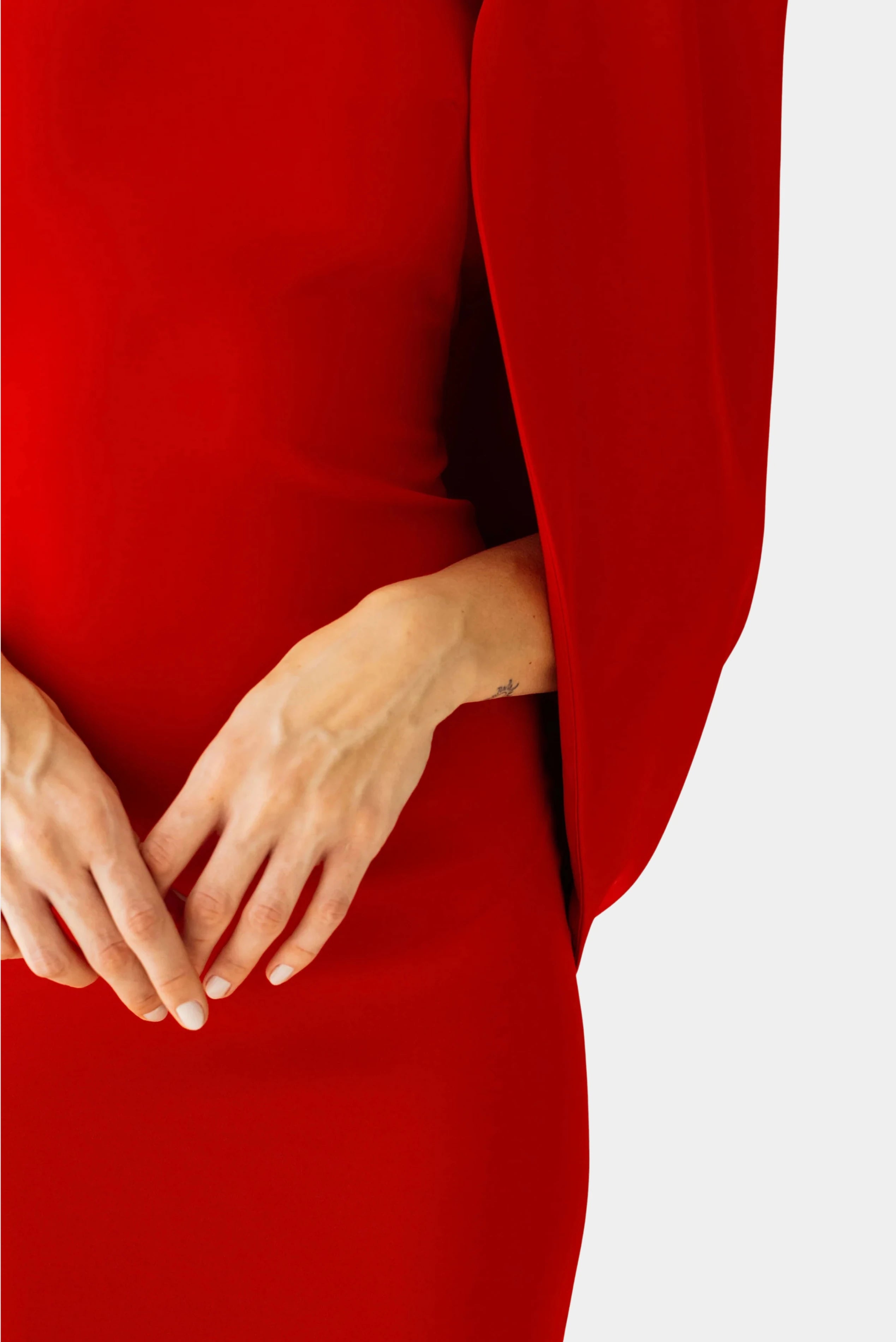 Detalhe lateral do vestido longo vermelho Eter Ostra Minú com capa e acabamento minimalista