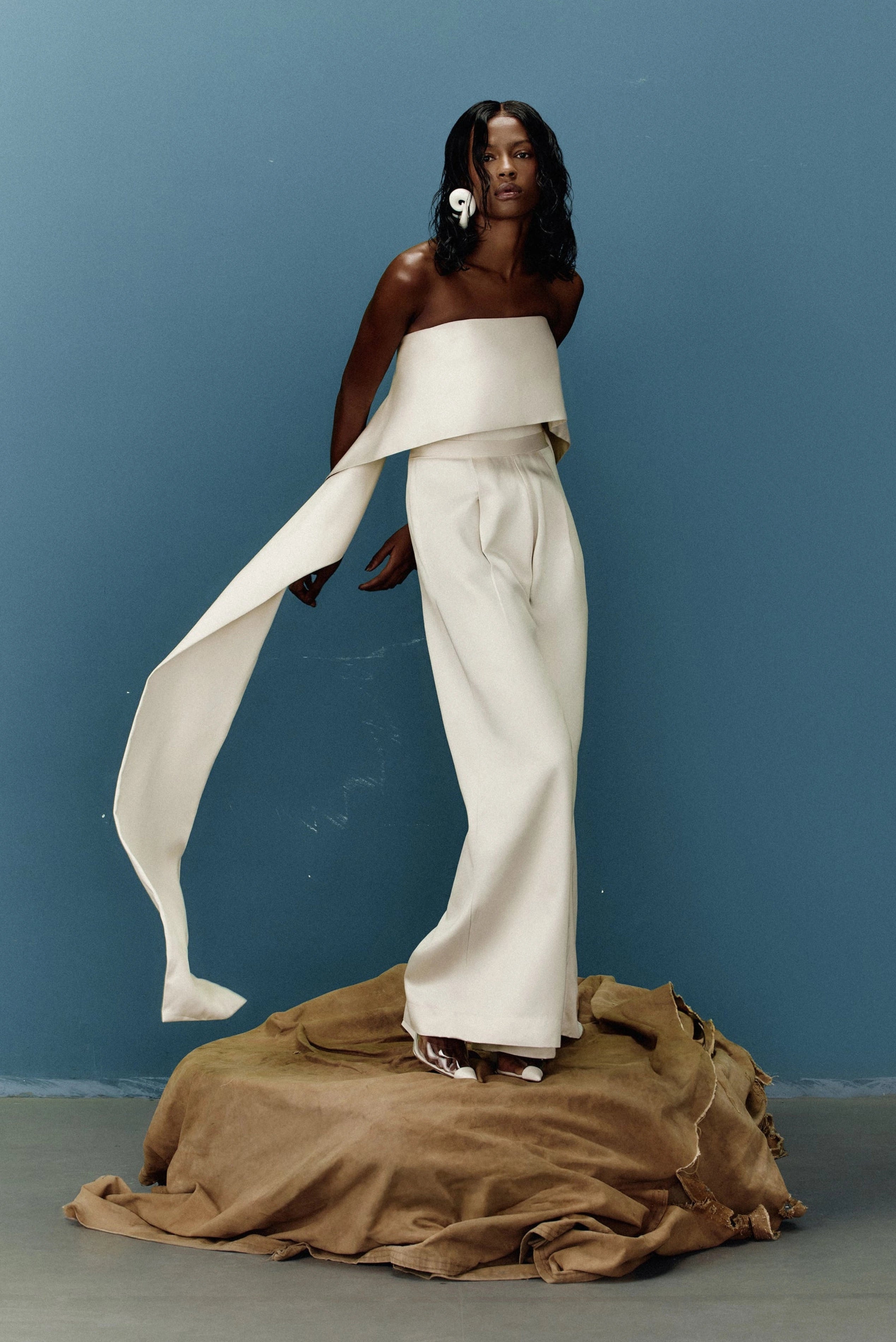 Macacão Nácar Minú off-white com faixa drapeada longa e calça ampla em editorial de moda
