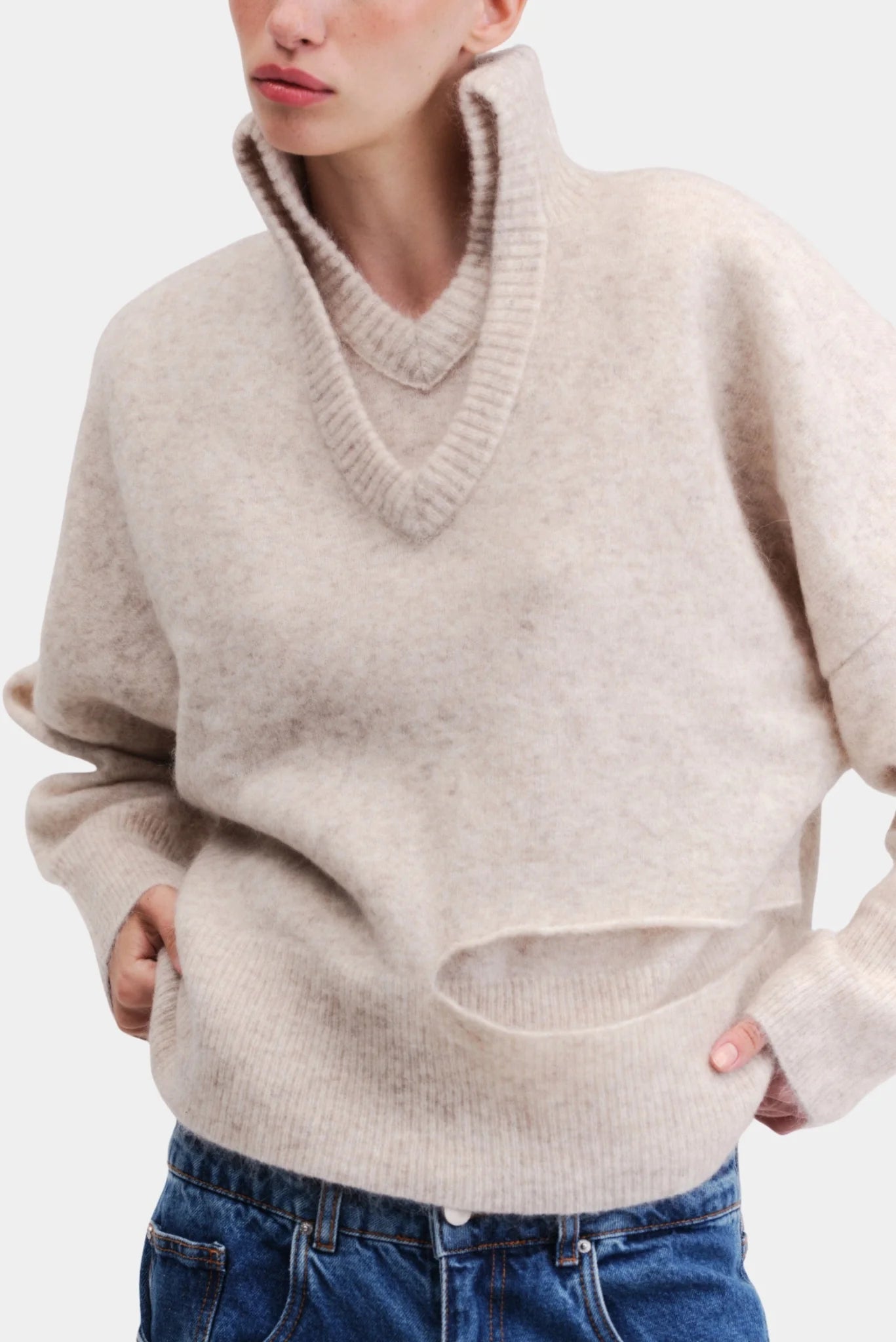 Pullover oversized em tricot bege com gola alta canelada e detalhe frontal vazado