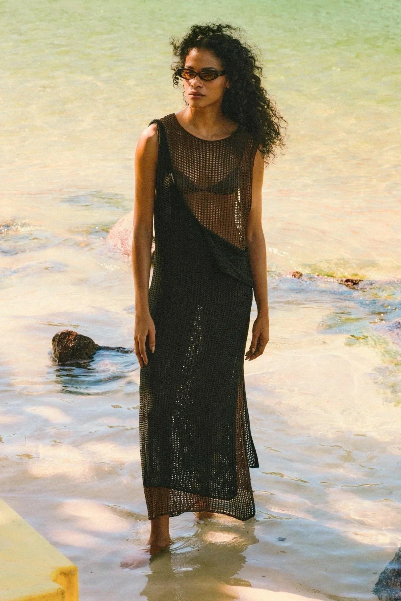 Modelo usando vestido midi Haight em tricot vazado marrom sobre look de praia