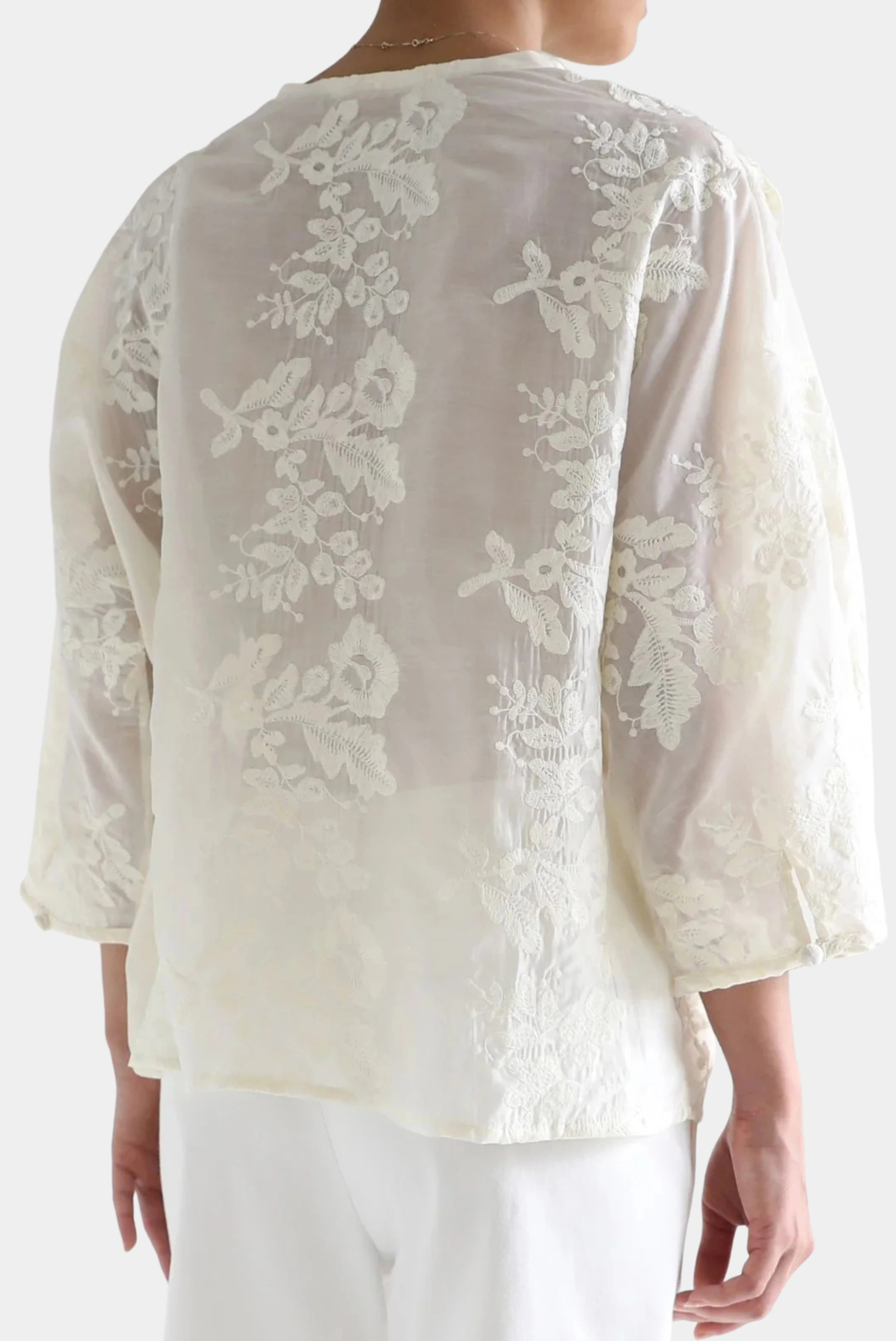 Costas da Camisa Renda Localizada Renda Ostra com renda floral e mangas amplas.
