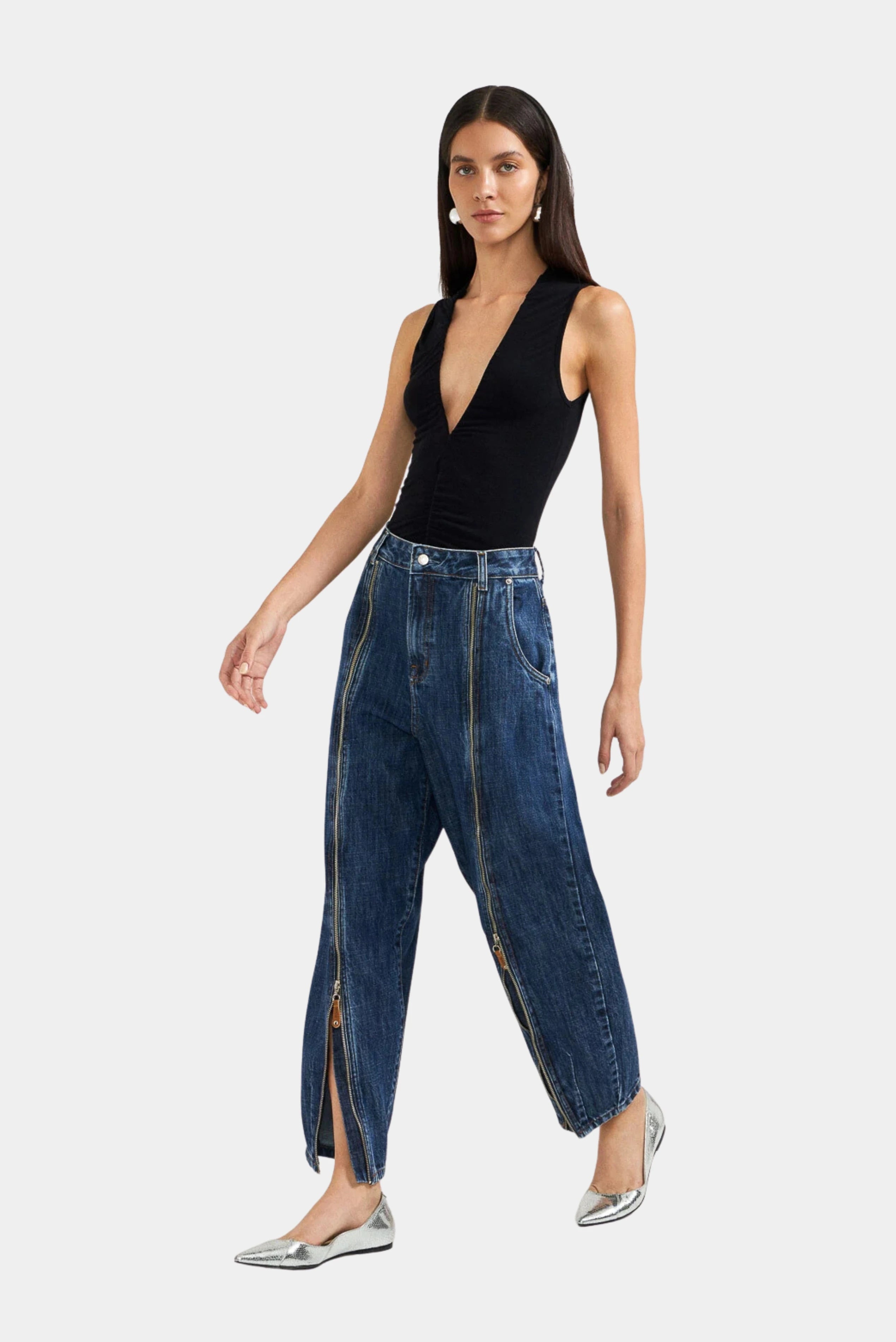 Vista lateral da calça jeans balloon azul escuro com zíperes frontais e barra ajustável LDnim