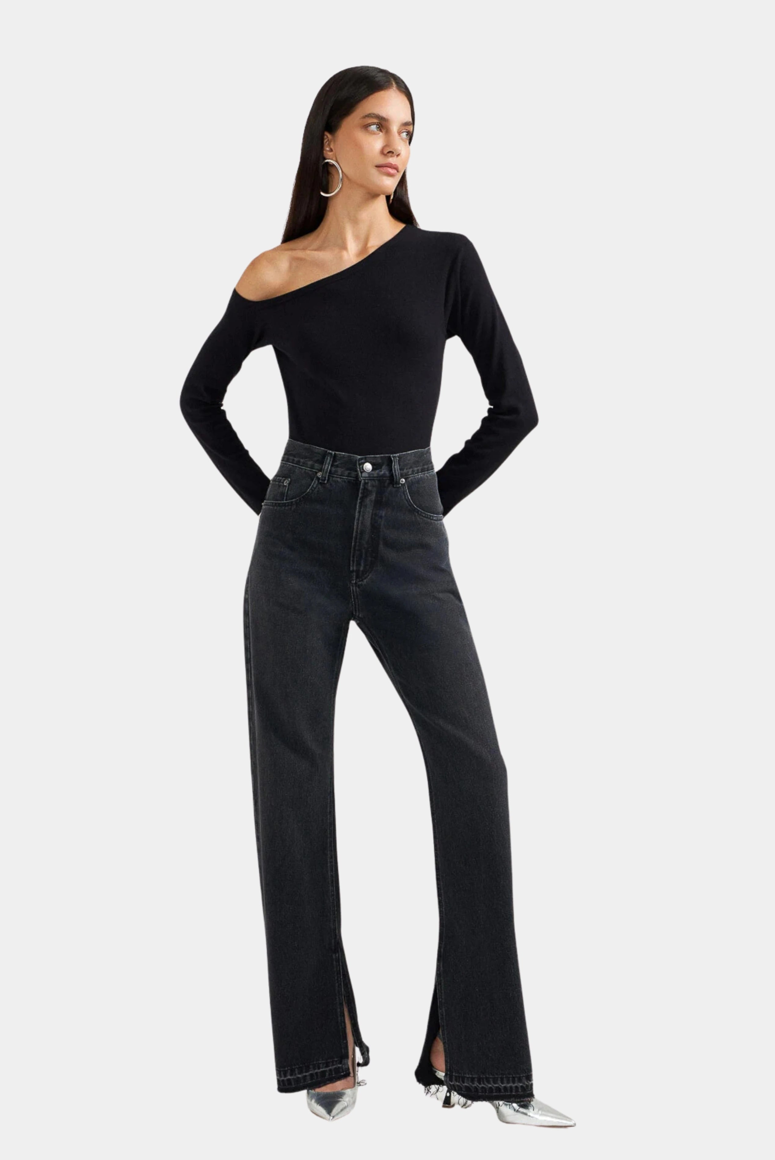 Modelo usando calça jeans 90s preta de cintura alta com modelagem reta e barra com fenda frontal LDnim