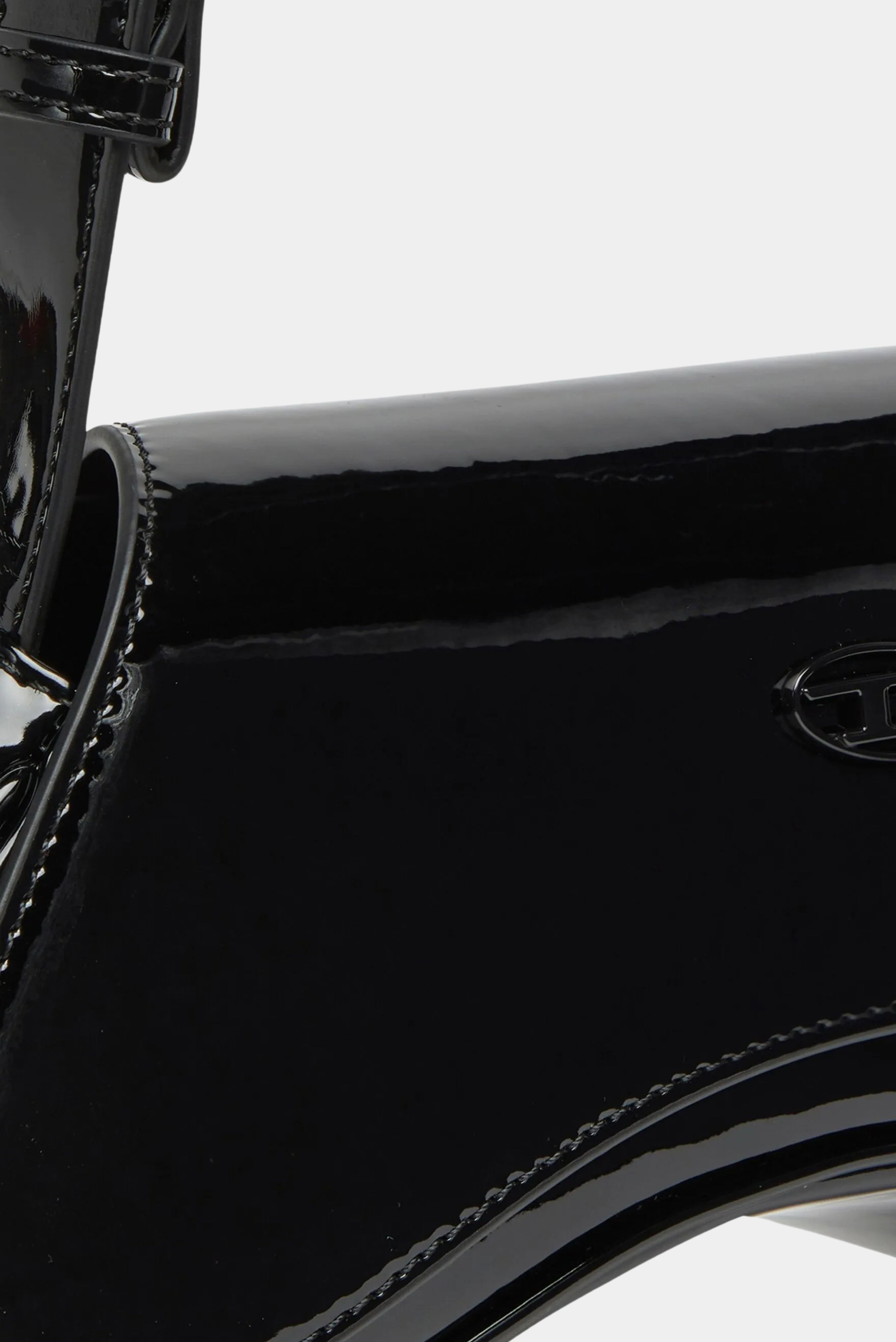 Detalhe da bolsa Diesel preta em verniz com acabamento espelhado e costura aparente