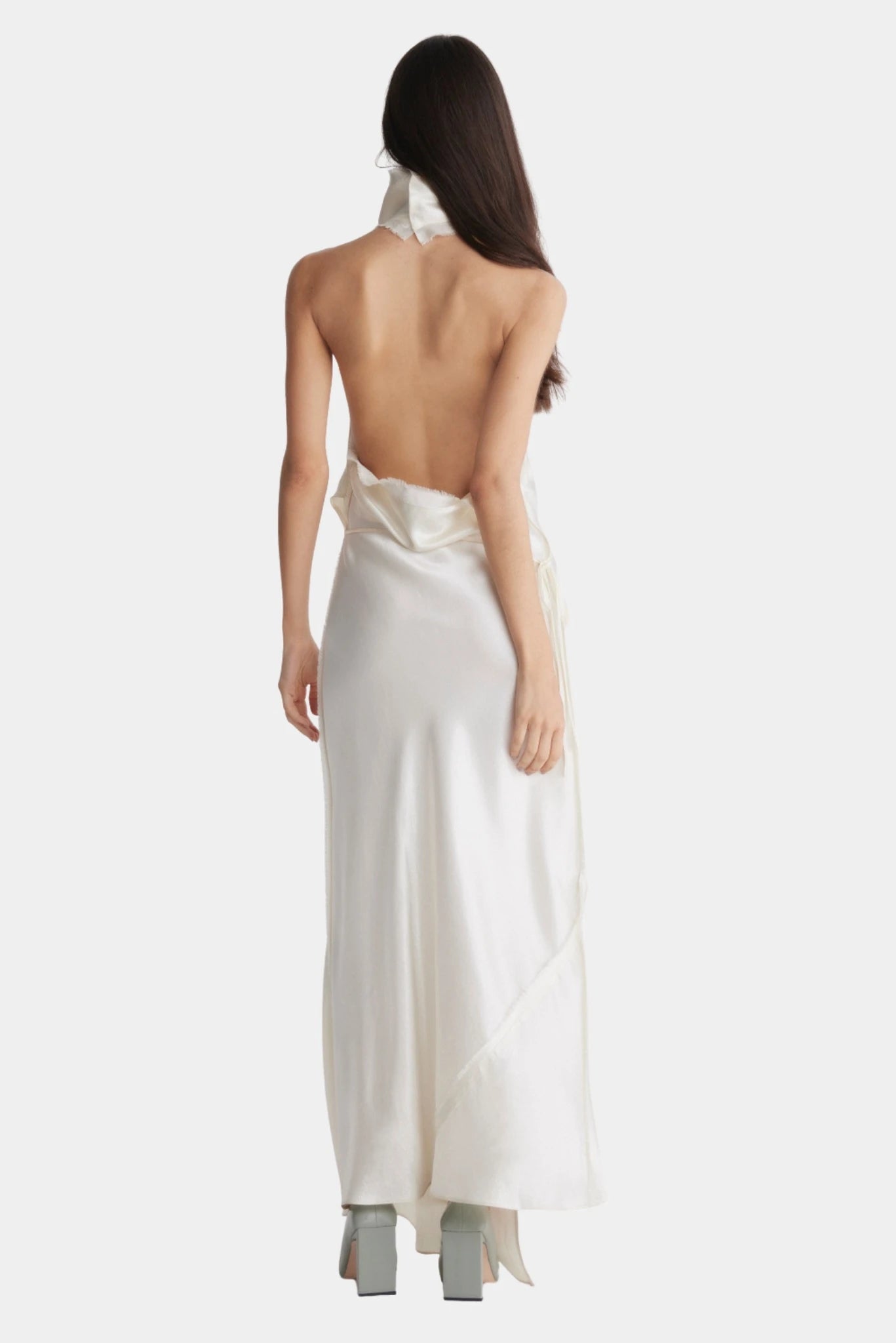 Costas do vestido longo off-white com decote aberto e modelagem fluida