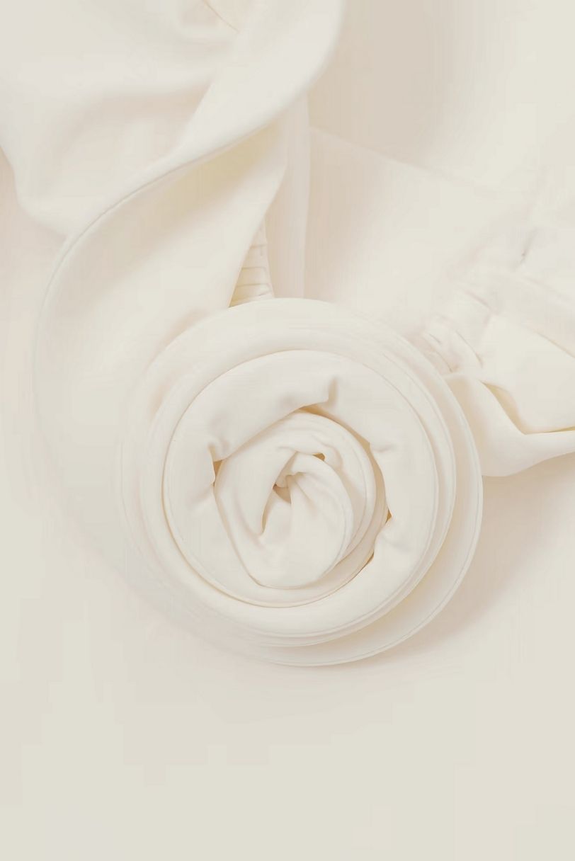 Detalhe de rosa aplicada em maiô off-white Magda Butrym com acabamento drapeado