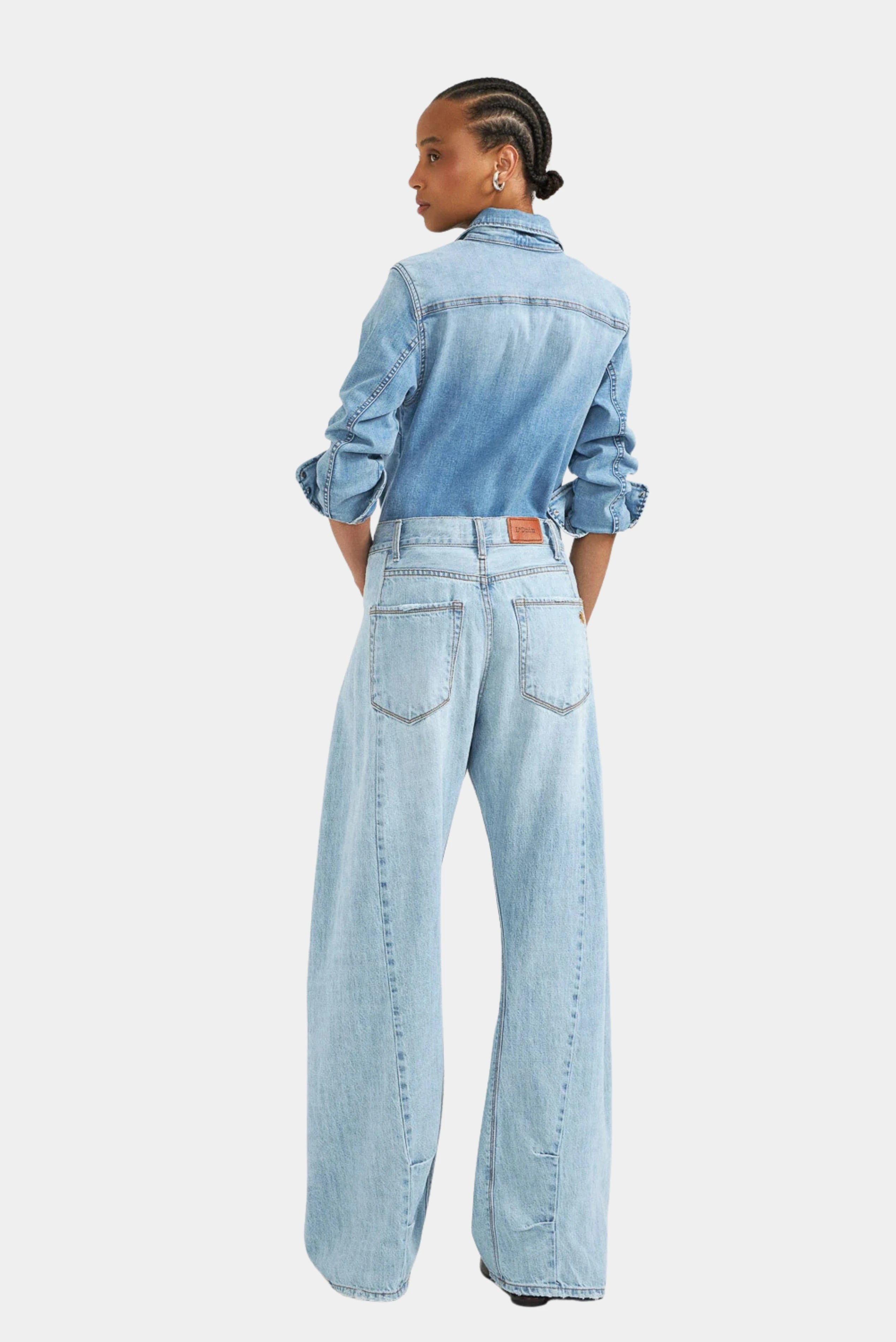 Calça jeans azul-claro wide de cintura alta com modelagem ampla, vista traseira na modelo LDnim