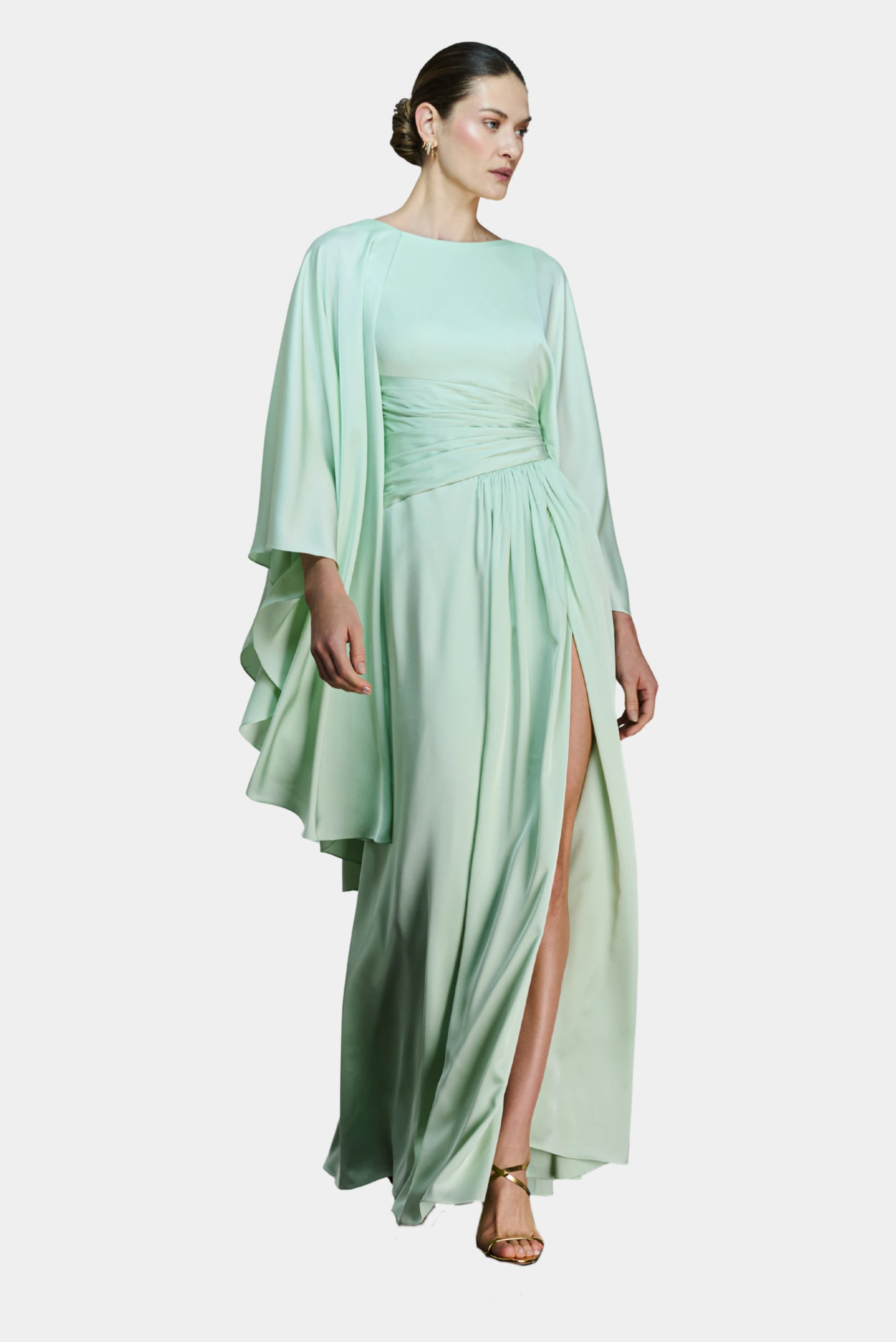 Modelo com vestido longo verde-menta de pala assimétrica drapeada, fenda frontal e capa fluida Fatima Scofield