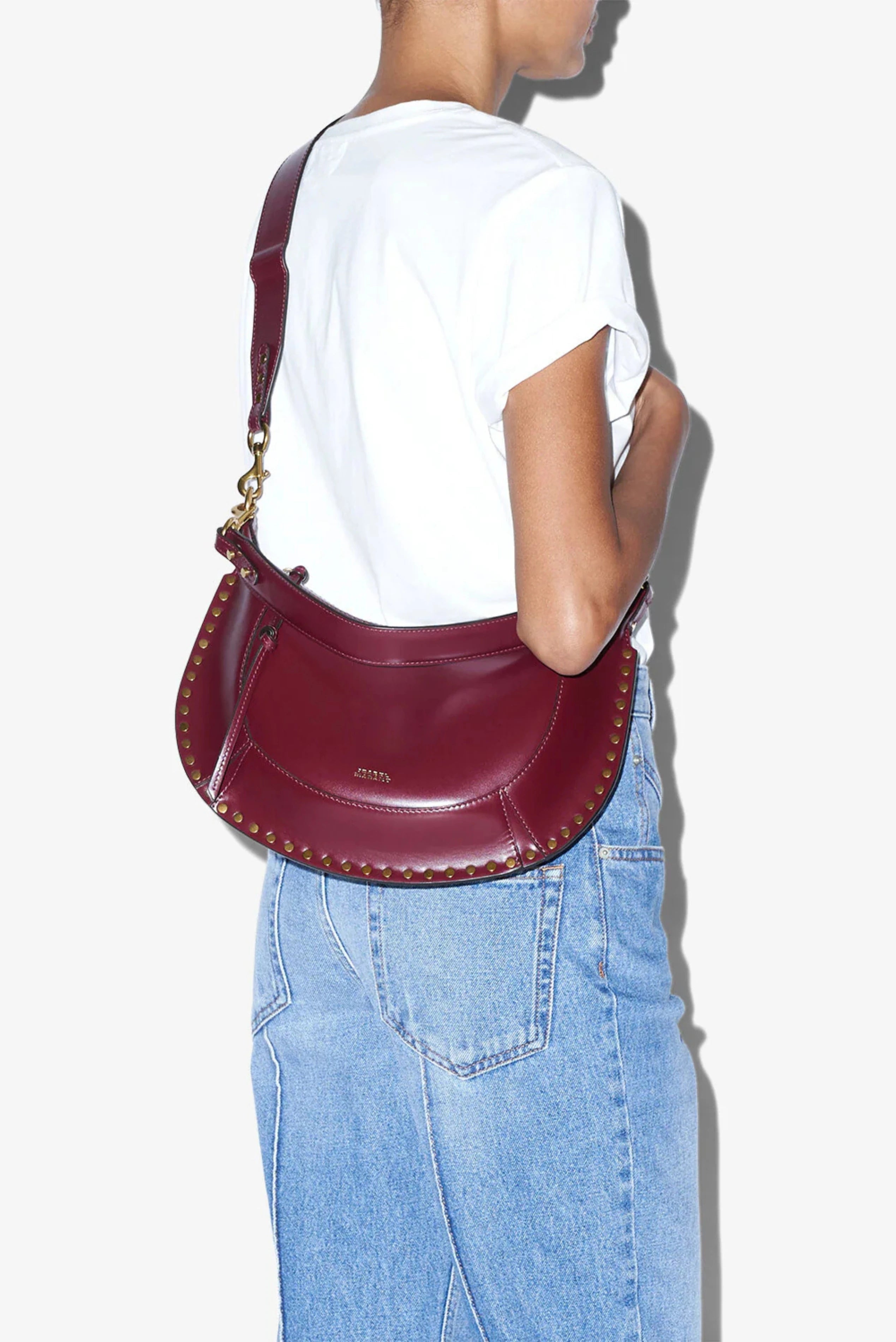 Modelo usando bolsa Isabel Marant Naoko em couro bordô com tachas douradas