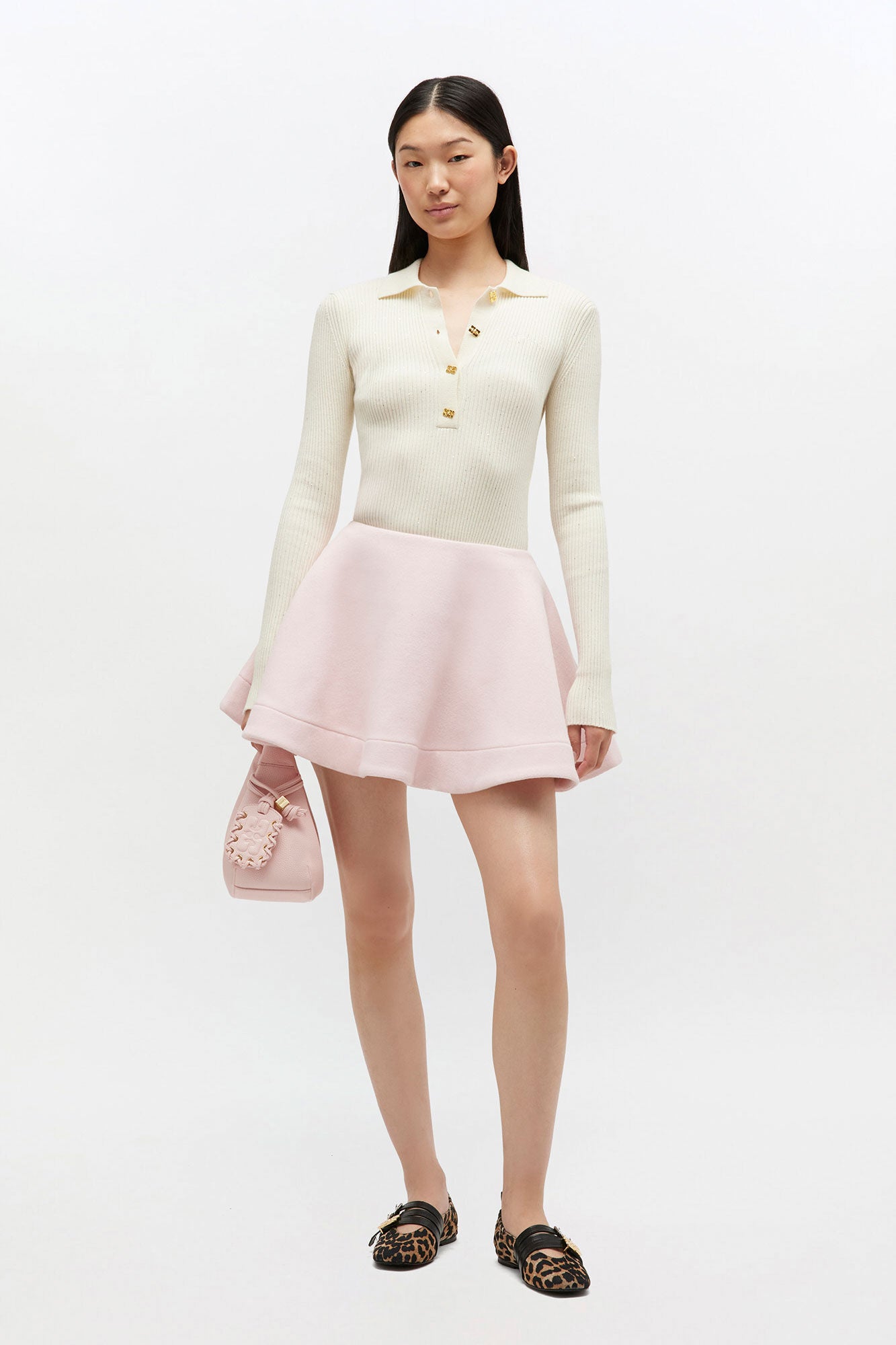 Modelo usando saia Ganni Peacoat rosa-claro em lã com modelagem evasê curta