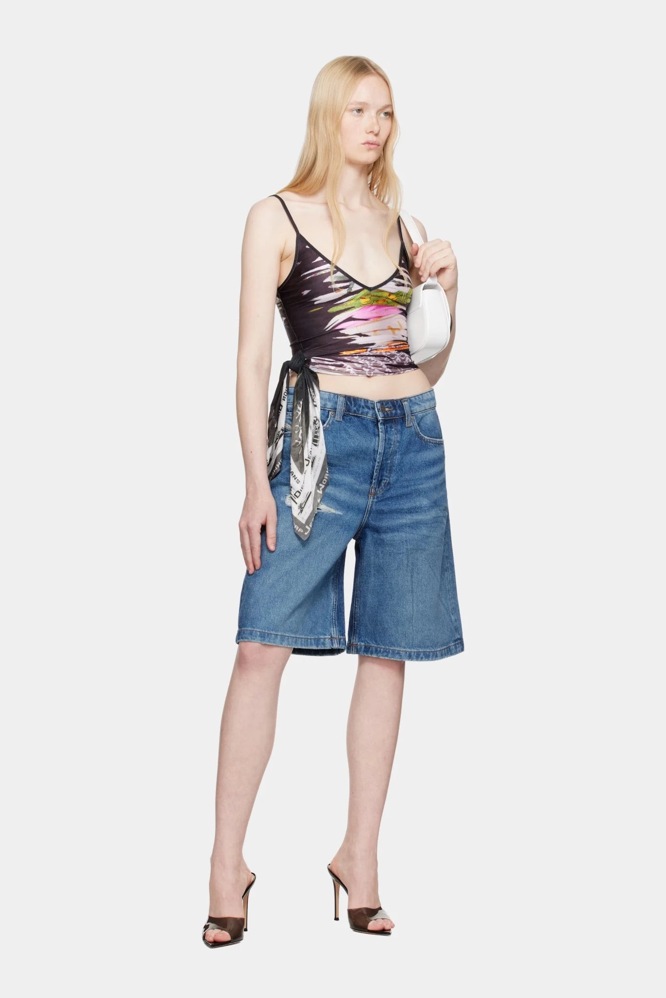 Modelo usando bermuda jeans Diesel azul com lavagem clara e modelagem ampla