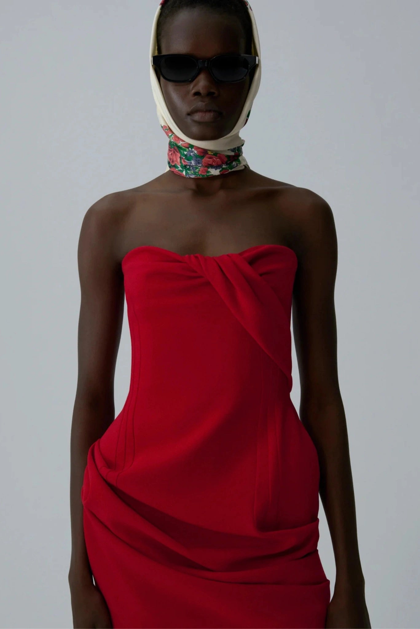 Modelo usando vestido mini vermelho tomara que caia com corset e drapeado assimétrico