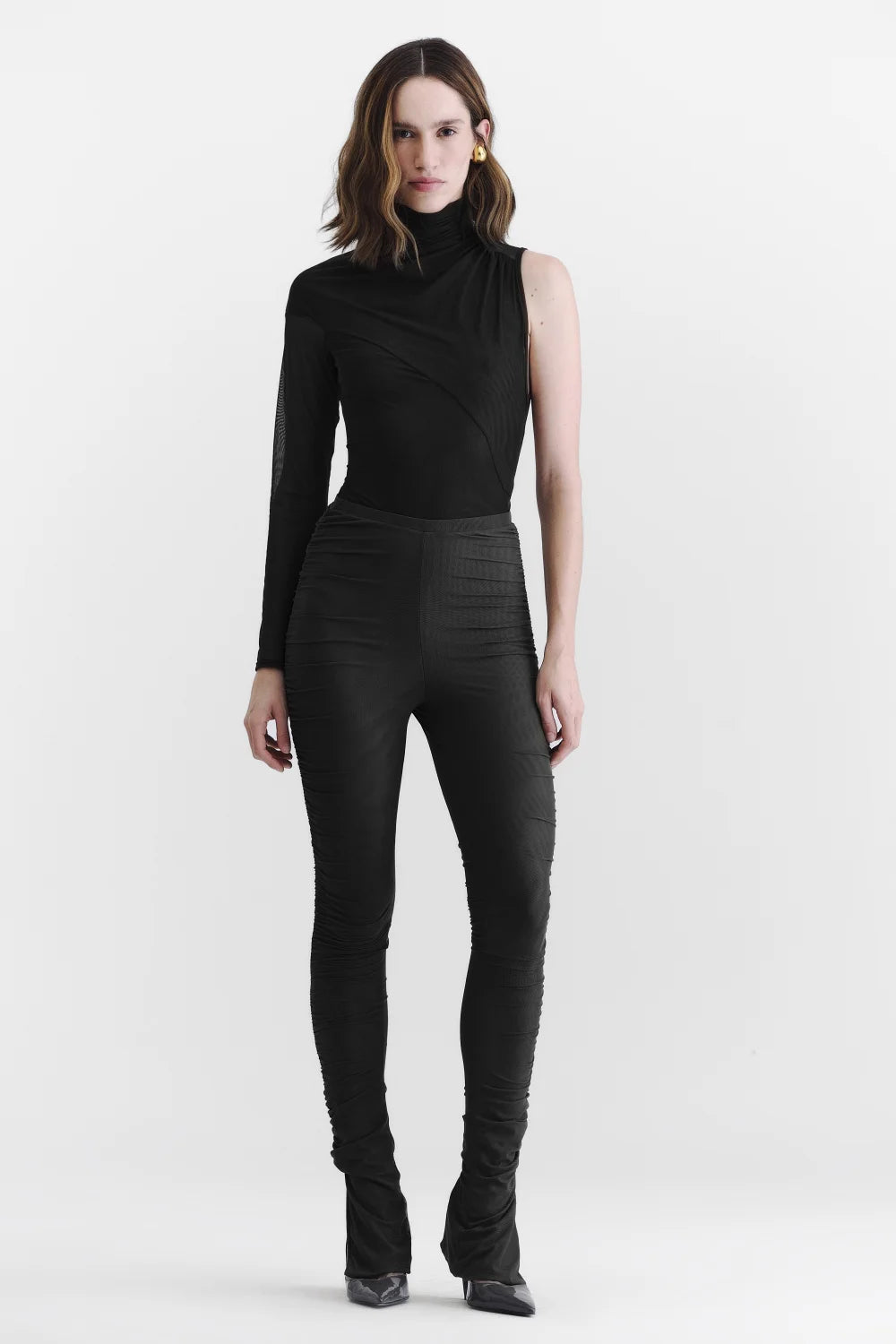 Body assimétrico preto com gola alta, uma manga longa e recorte sem manga em look feminino