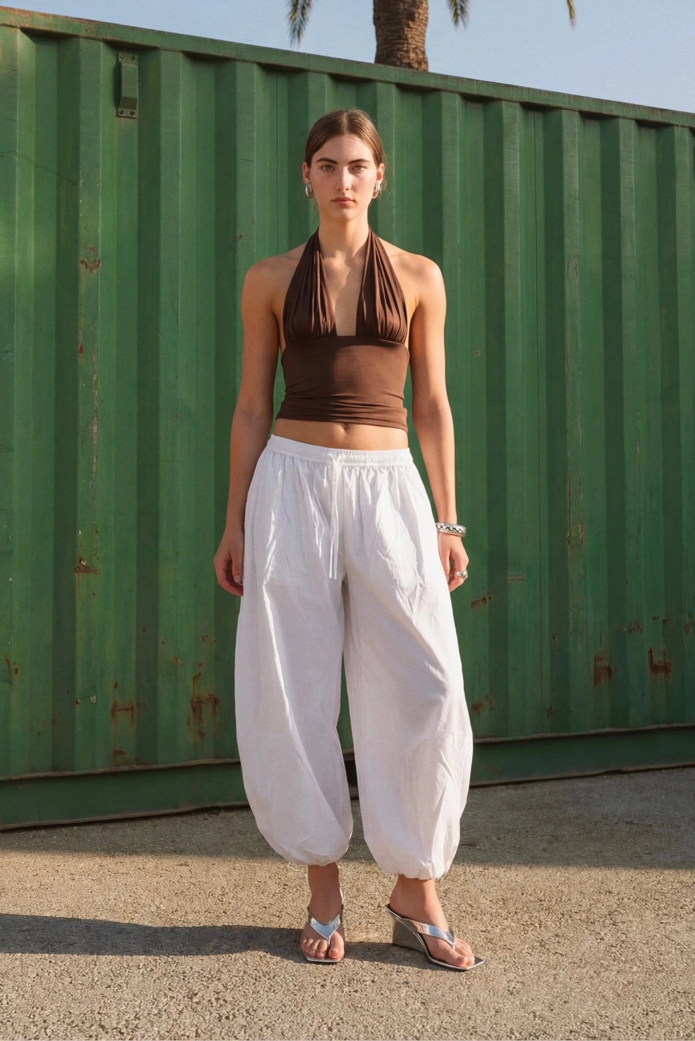Modelo usando calça bloomer branca em tricoline com modelagem ampla e barras ajustadas