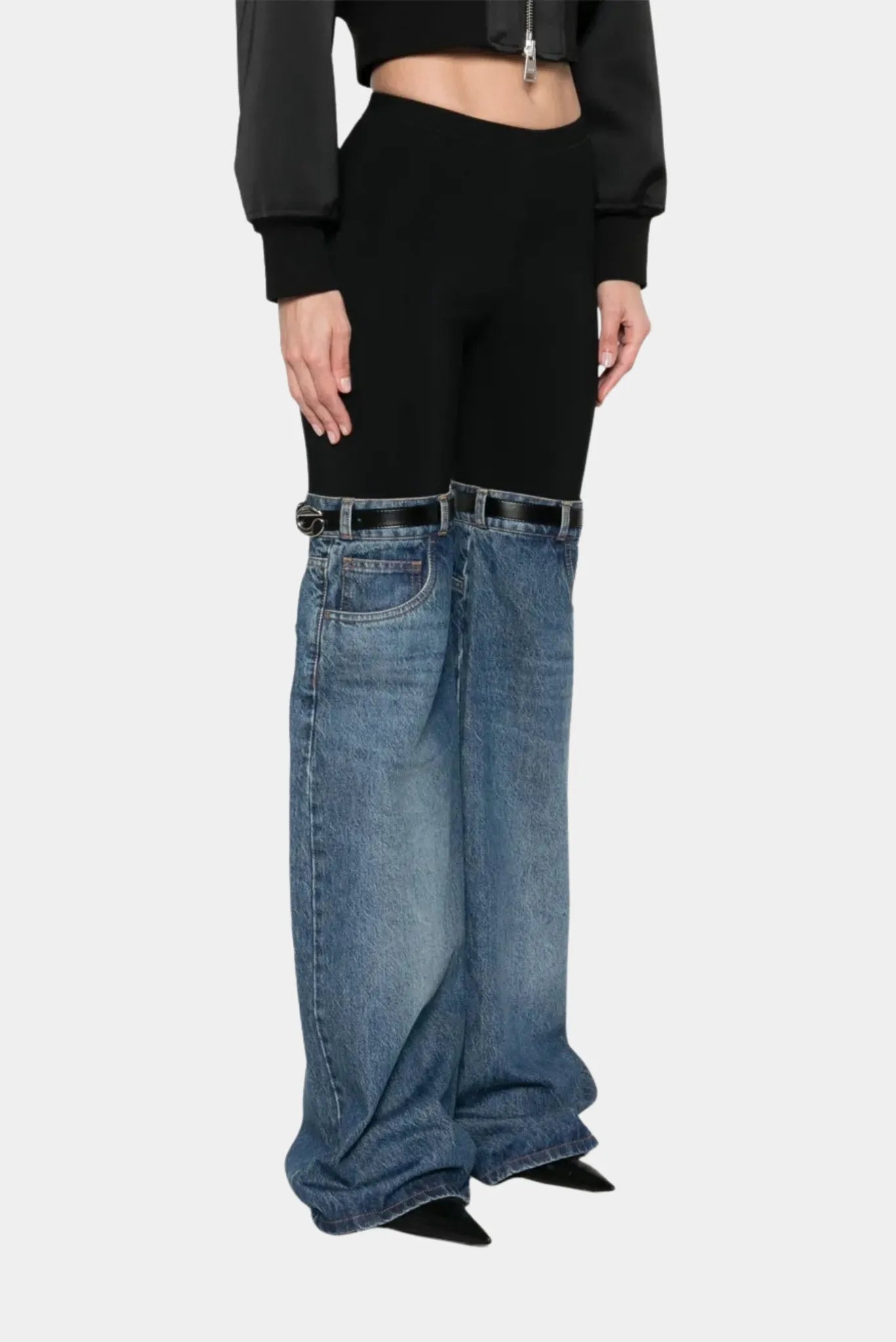 Detalhe de calça híbrida Coperni com legging preta e jeans azul amplo