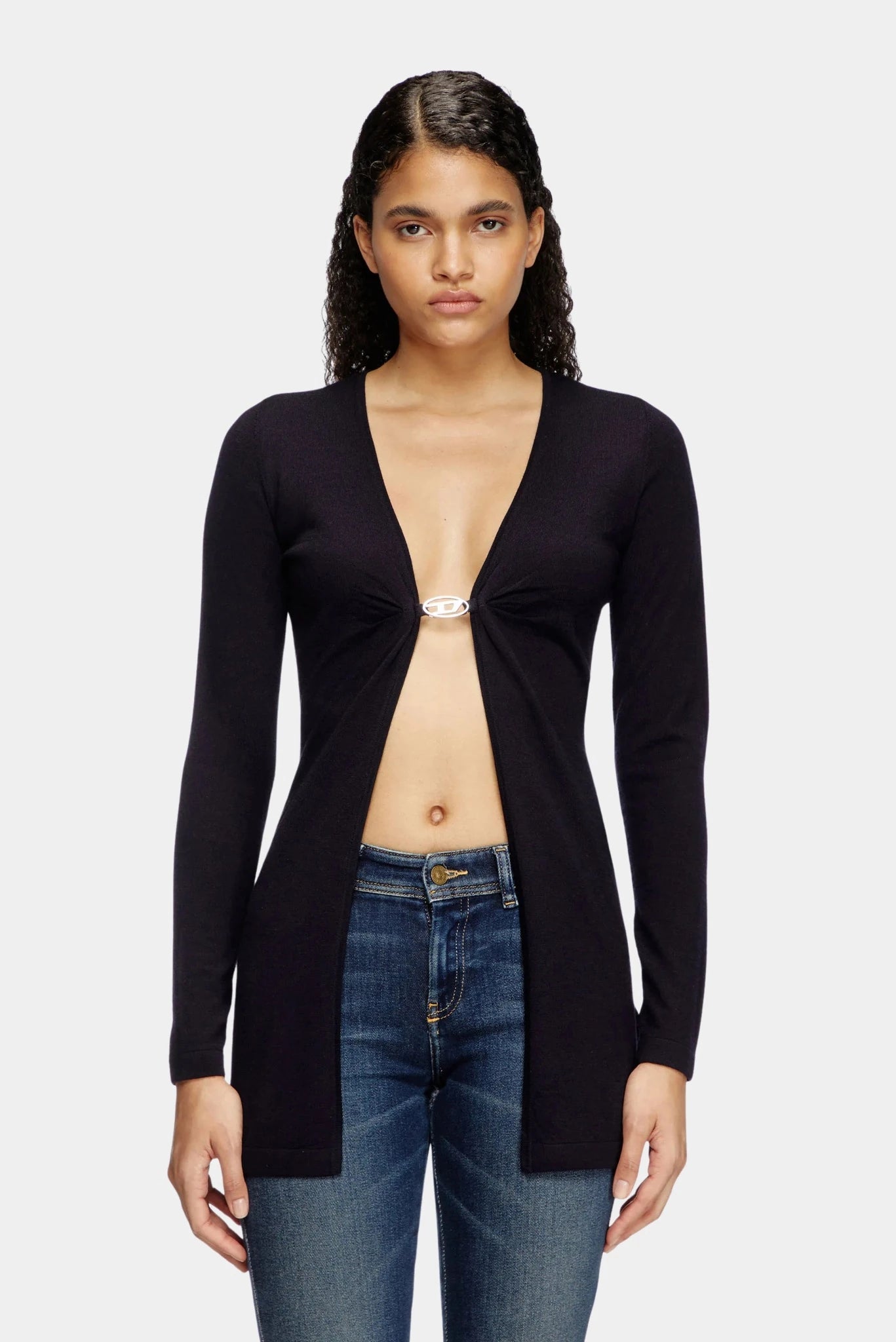 Modelo usando suéter preto Diesel com abertura frontal e jeans ajustado
