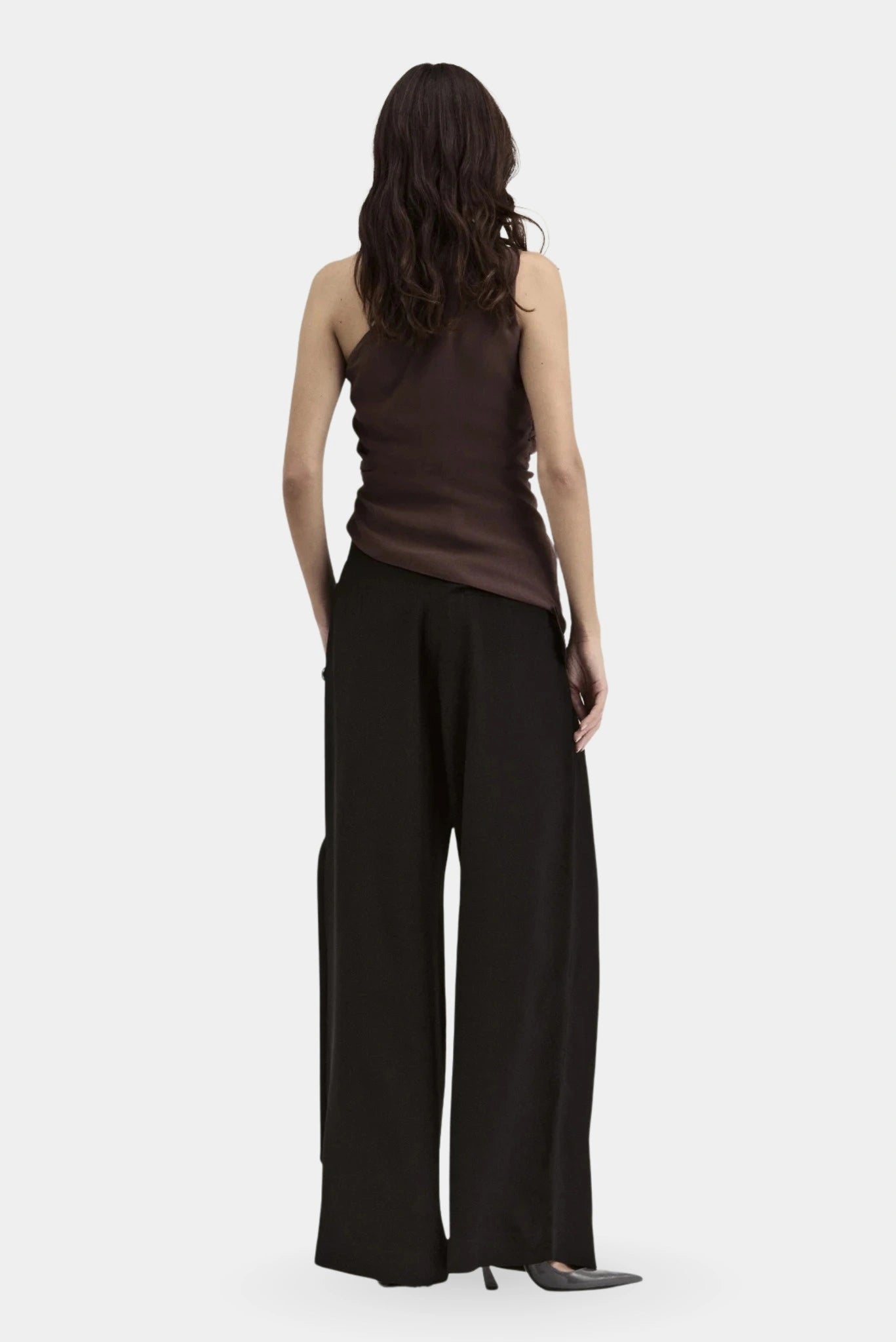 Costas da blusa marrom de um ombro com modelagem assimétrica