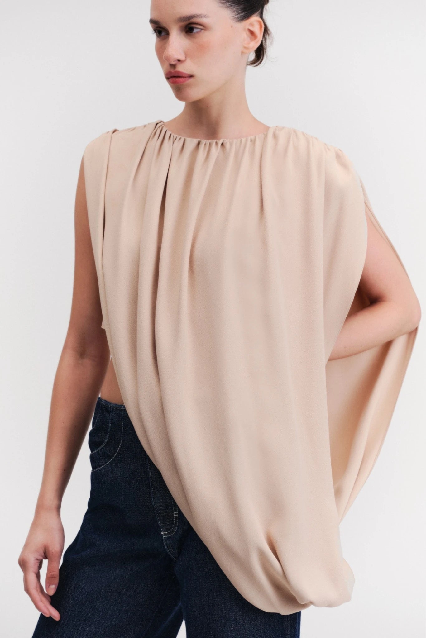 Blusa bege assimétrica com drapeado frontal e modelagem solta