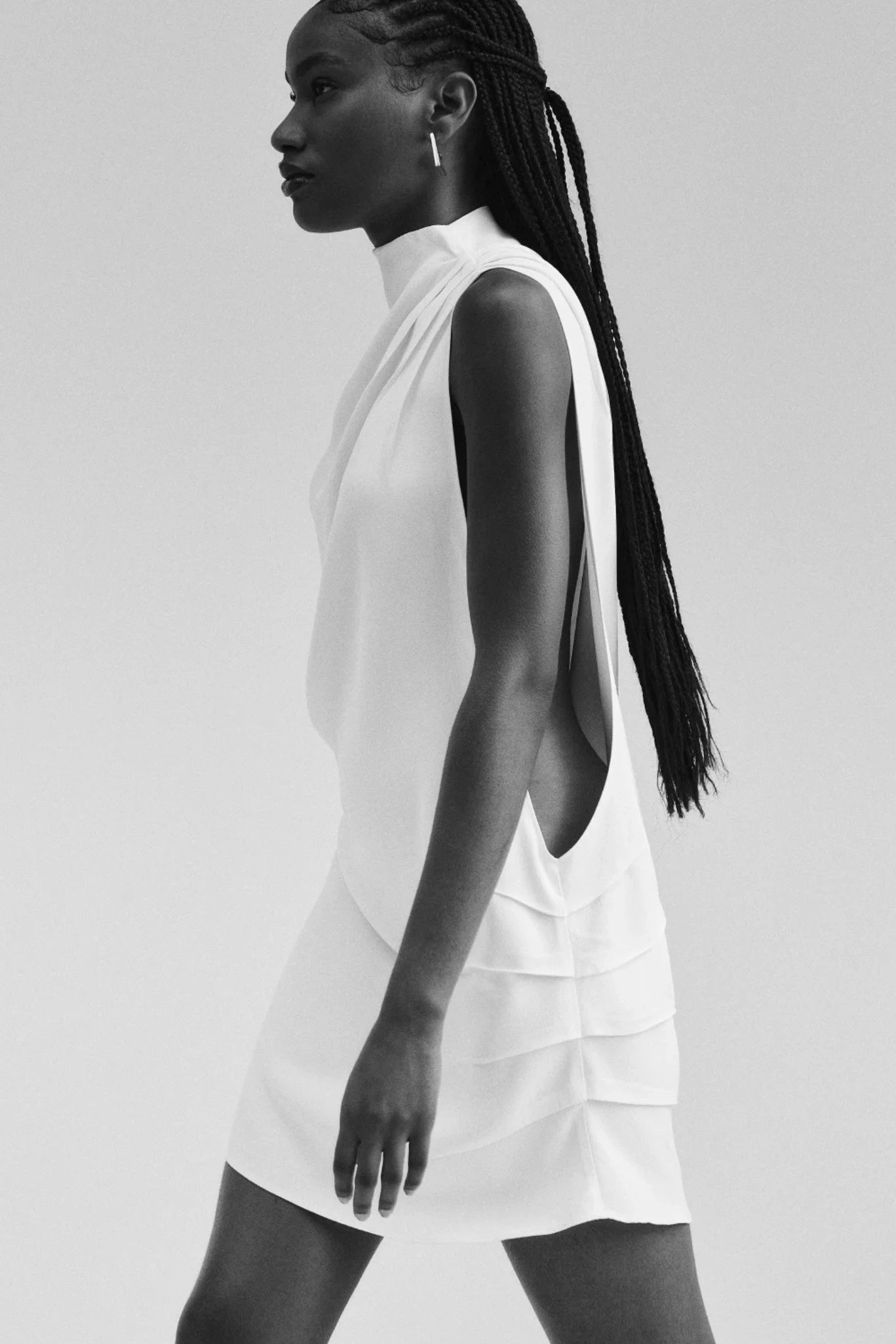 Detalhe lateral do vestido off-white com recorte profundo e caimento fluido