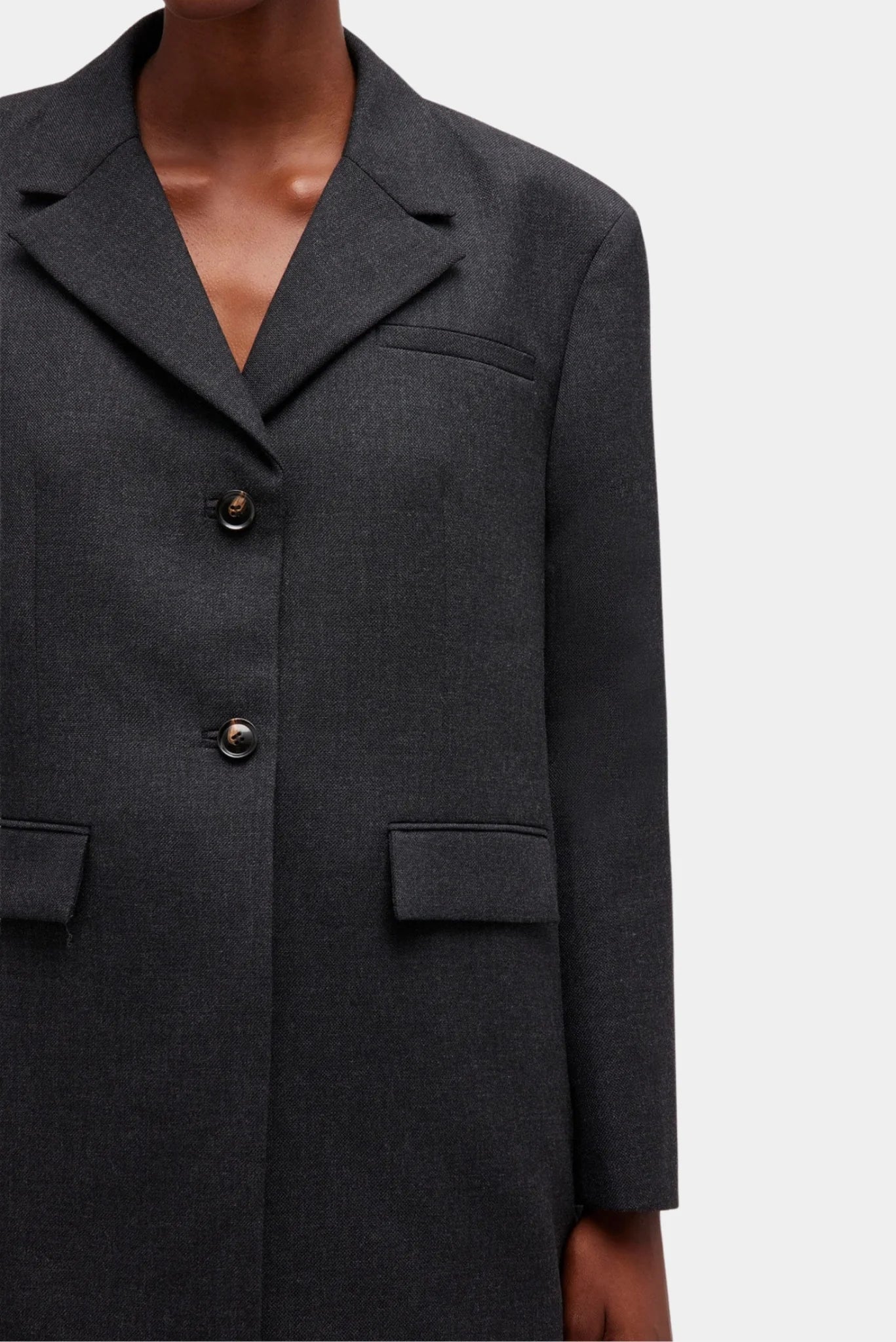 Detalhe do blazer Ganni em lã cinza com lapela clássica e botões frontais