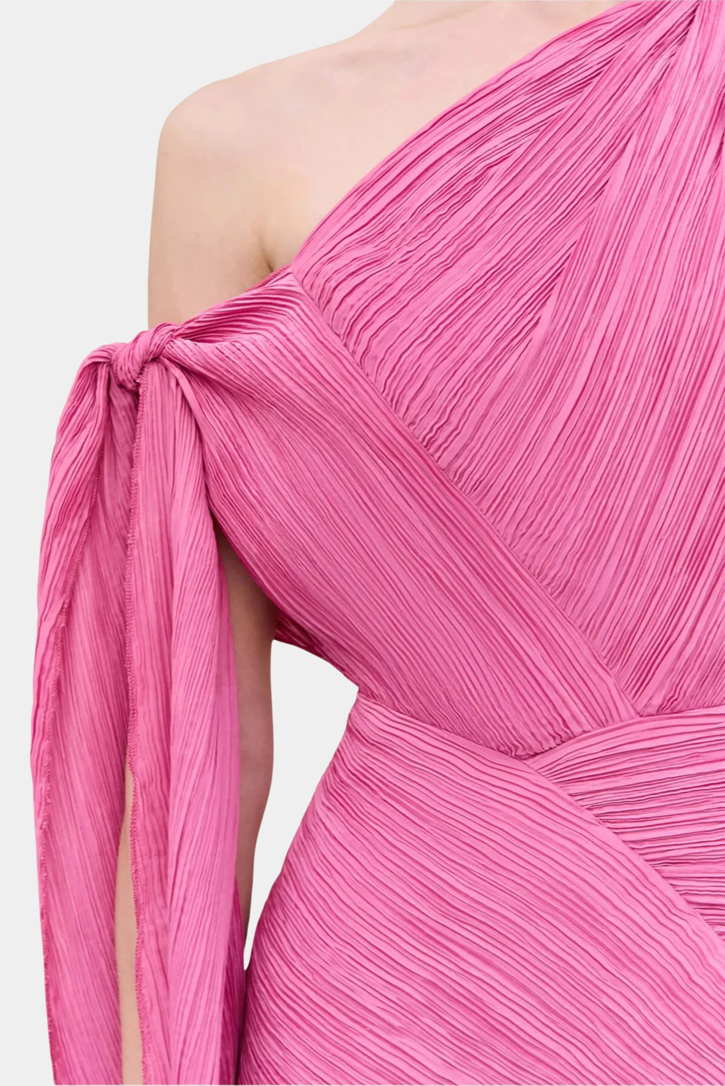 Close do vestido Cult Gaia em tecido plissado rosa com recorte assimétrico