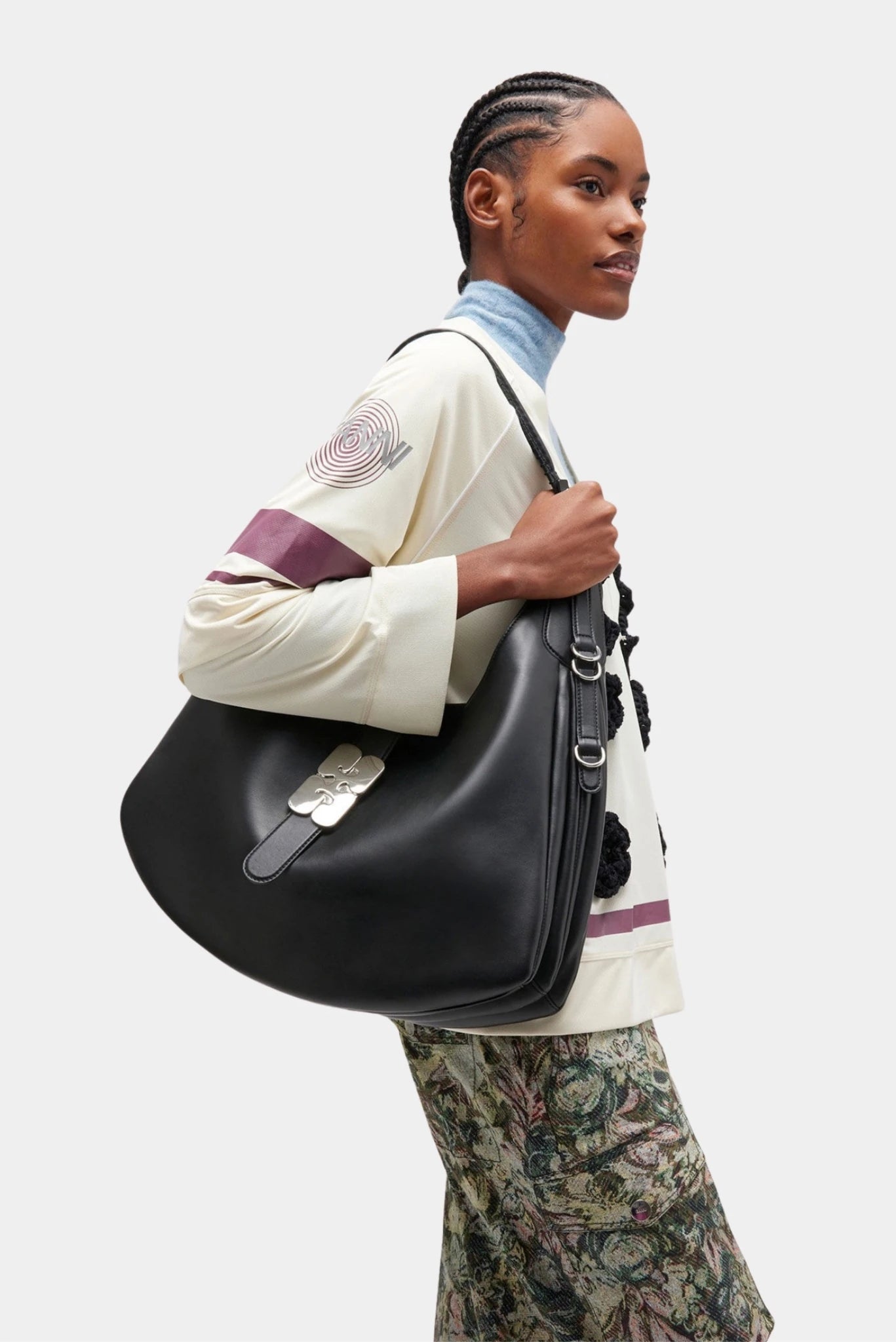 Modelo usando bolsa Ganni Kat Grande preta de ombro com design amplo