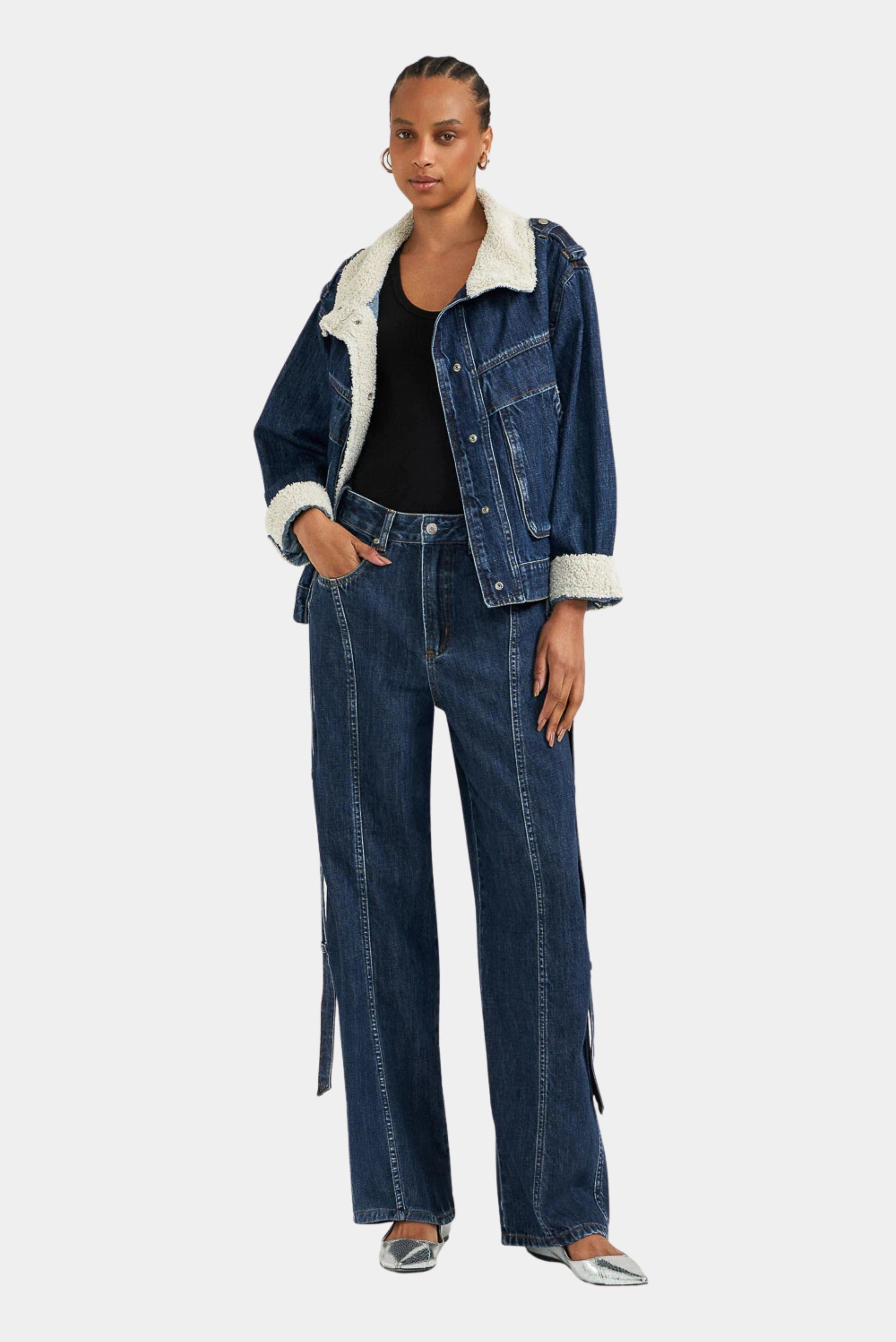 Modelo usando calça jeans baggy azul escuro com recortes laterais e modelagem ampla
