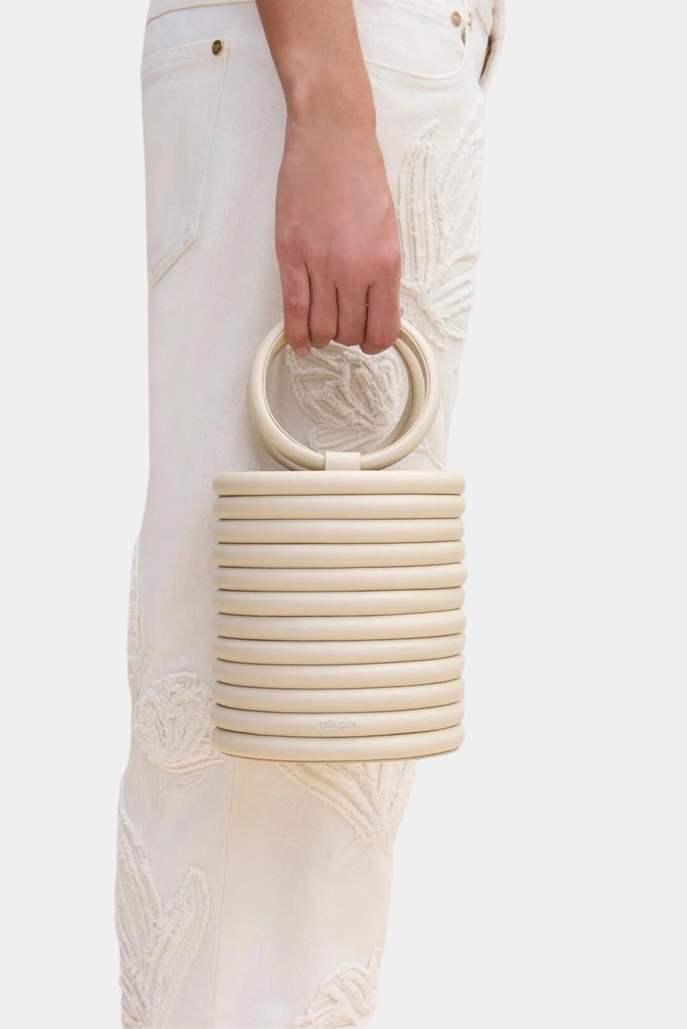 Bolsa de mão Yasmina Cult Gaia bege combinada com look monocromático claro