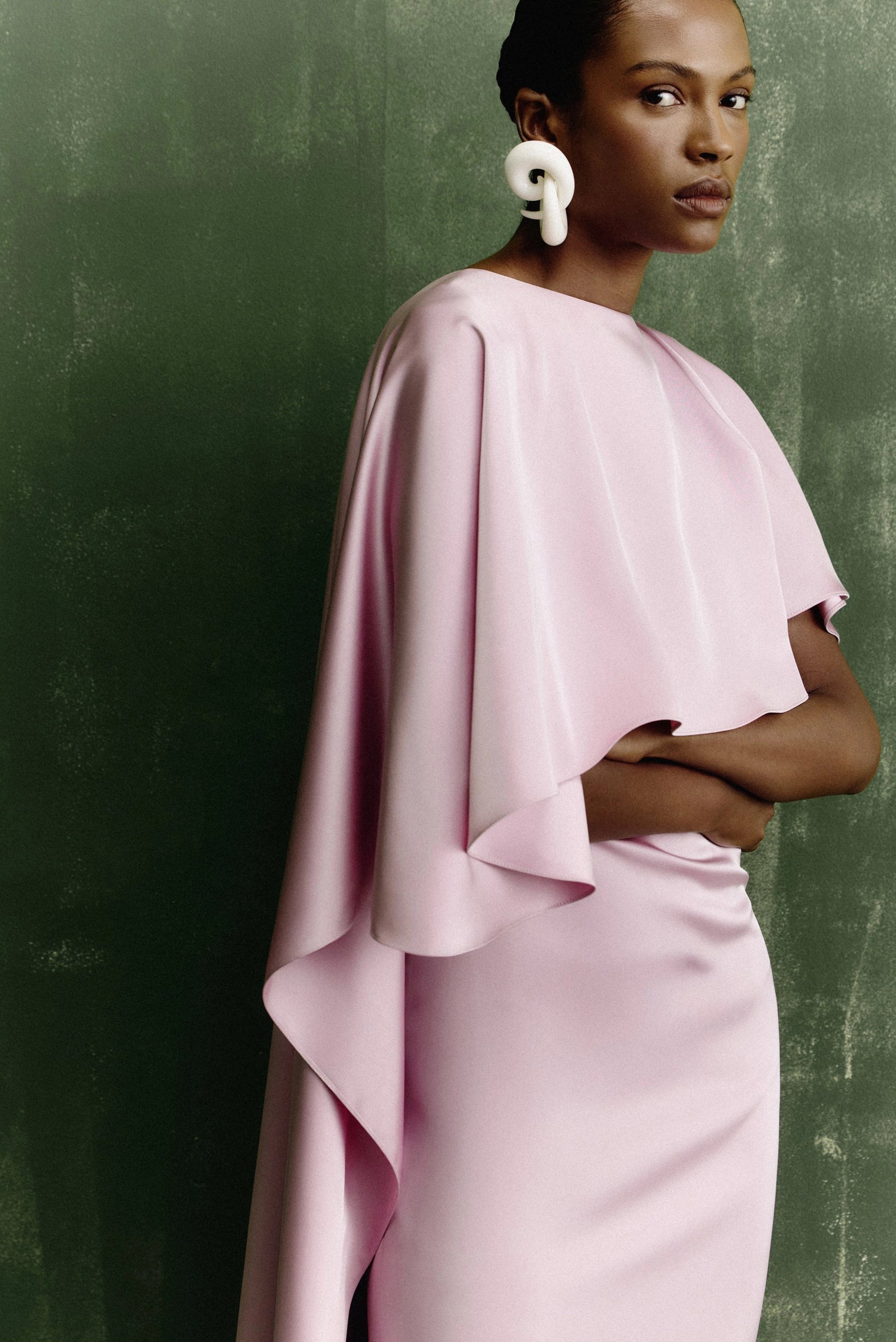 Vestido longo crepe rosa claro com capa fluida e modelagem elegante em imagem editorial
