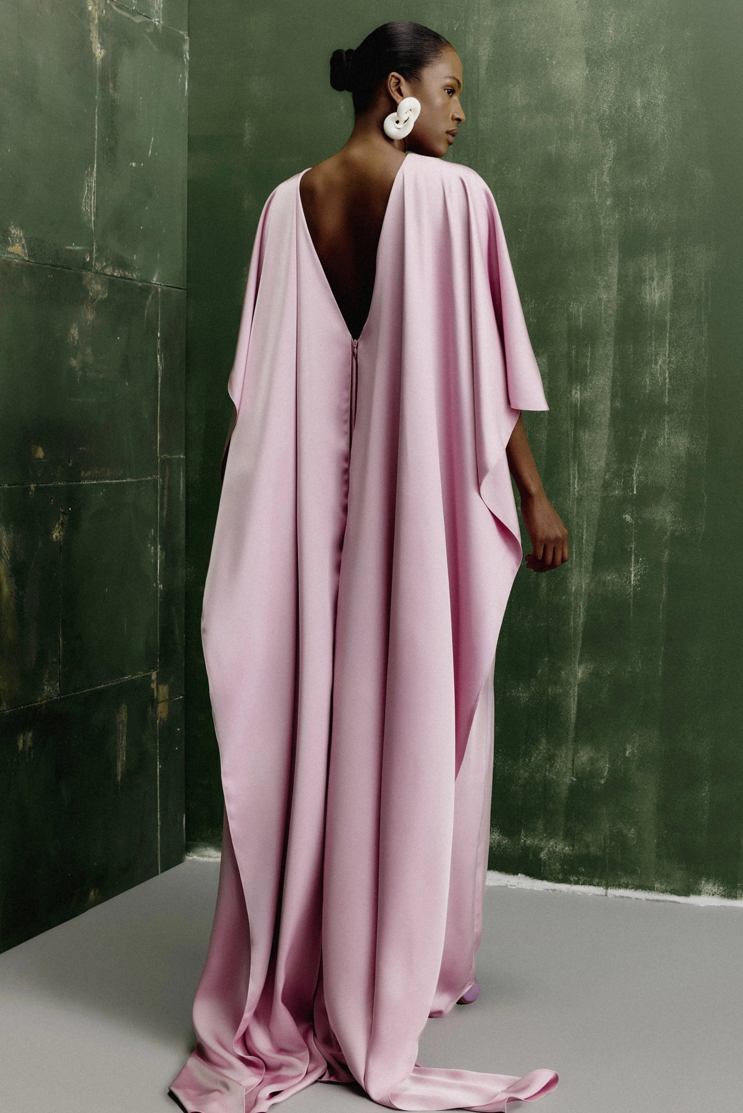 Vestido longo crepe rosa claro com capa fluida e modelagem elegante em imagem editorial
