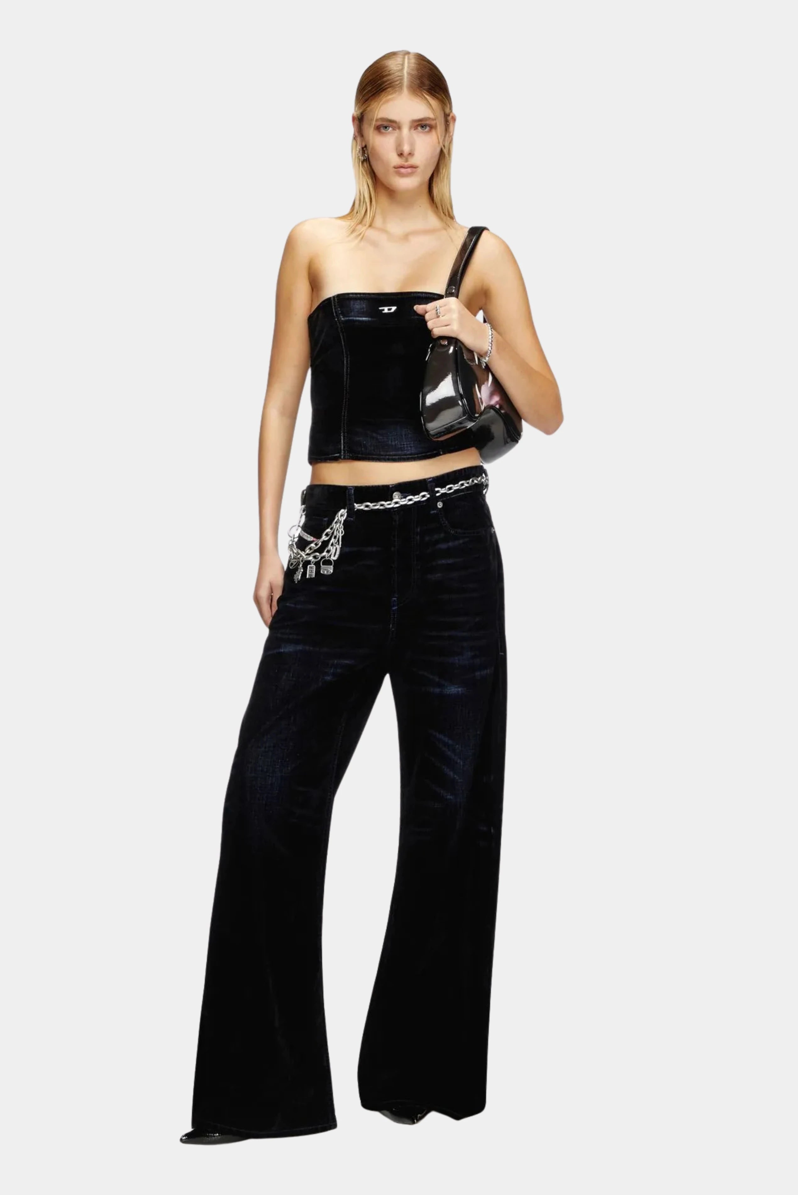Modelo usando calça jeans Diesel preta com pernas amplas