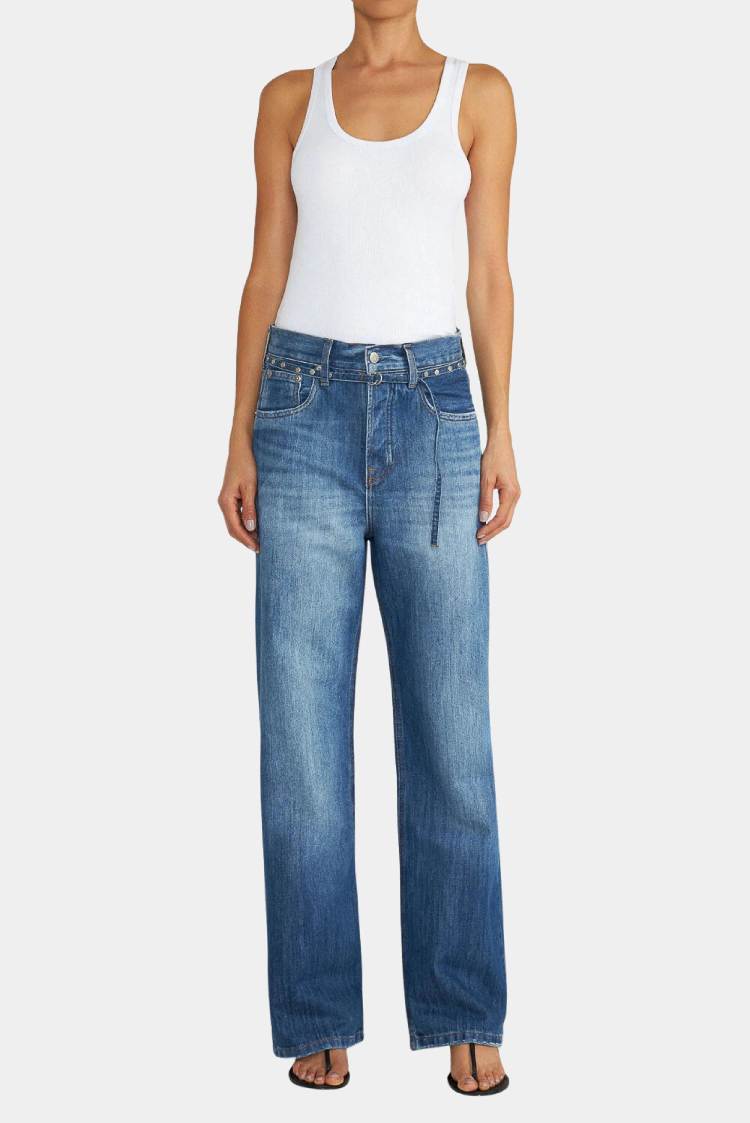 Calça jeans loose azul de cintura alta com pernas amplas e detalhe de faixa aplicada, vista frontal no corpo.