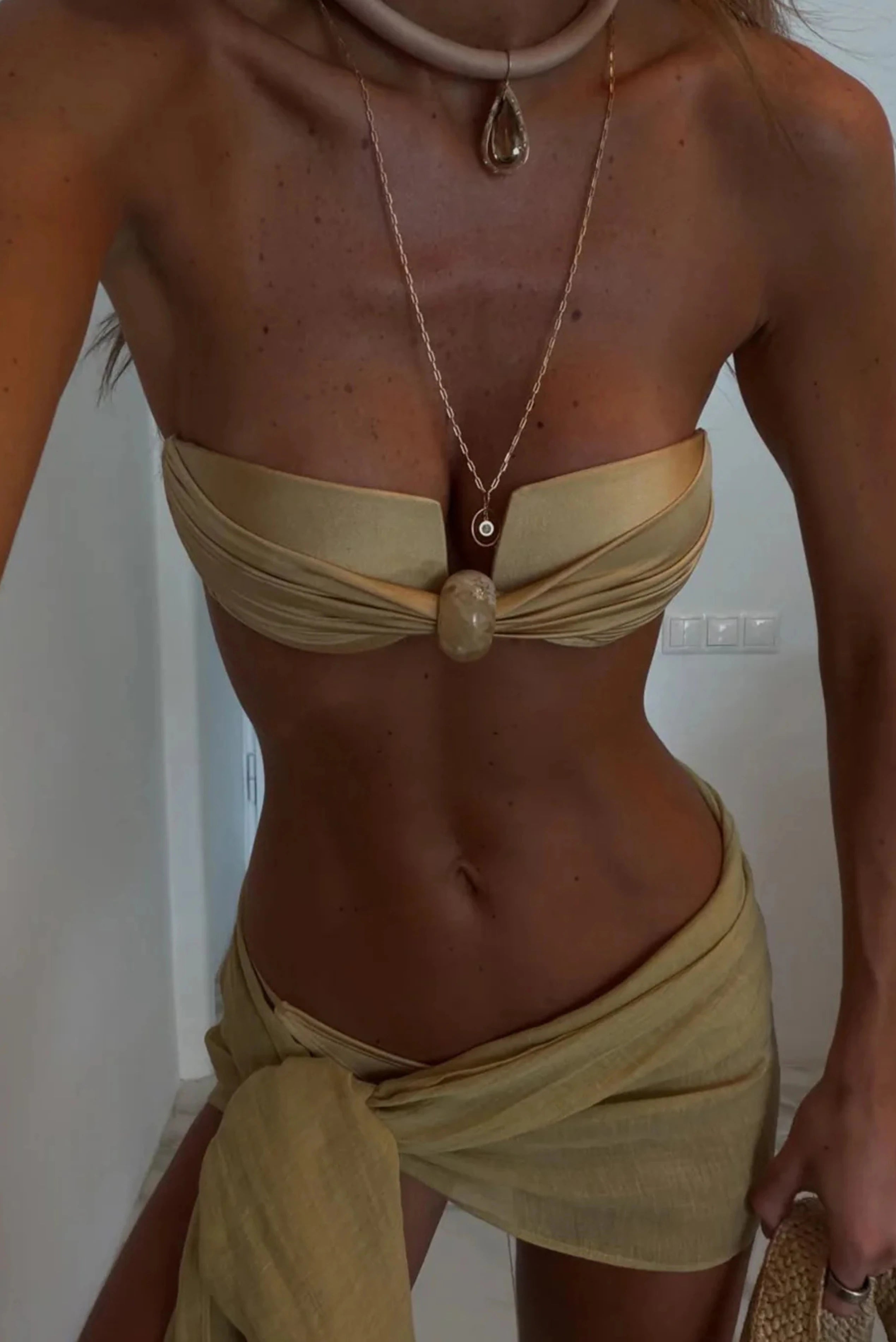 Pareo curto ostra com amarração lateral combinado com top tomara que caia em produção de moda praia.
