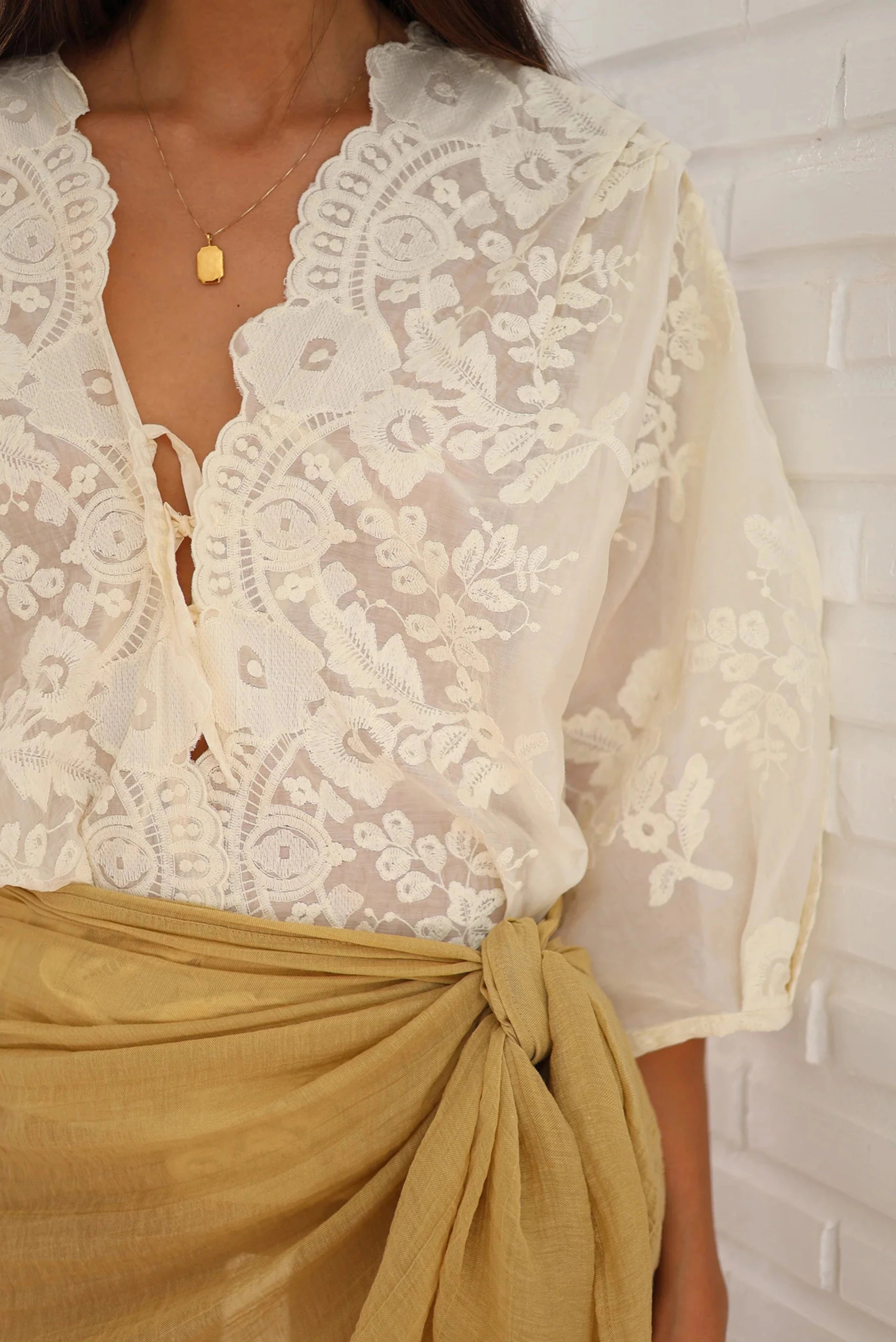 Close da Camisa Renda Localizada Renda Ostra com bordado floral e acabamento em renda.