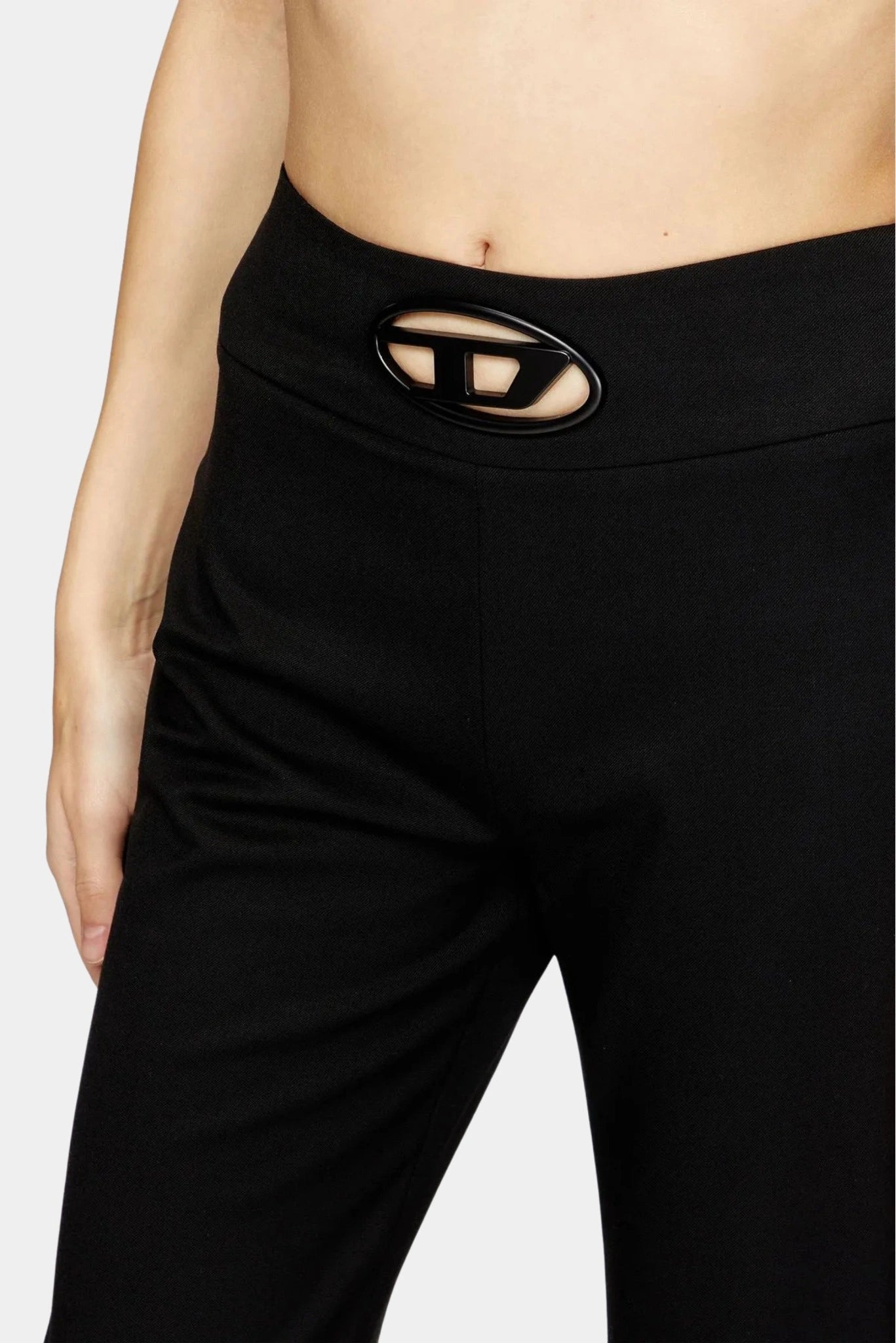 Detalhe da cintura com placa Oval D em calça preta Diesel