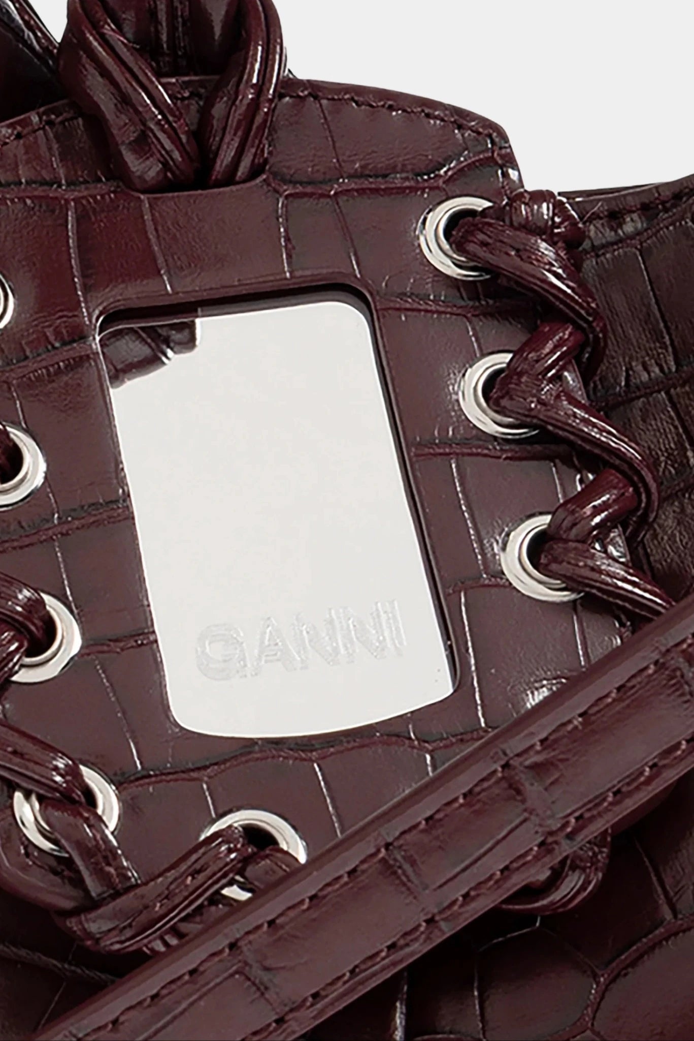 Detalhe da alça trançada com ilhós metálicos em bolsa hobo mini croco Ganni
