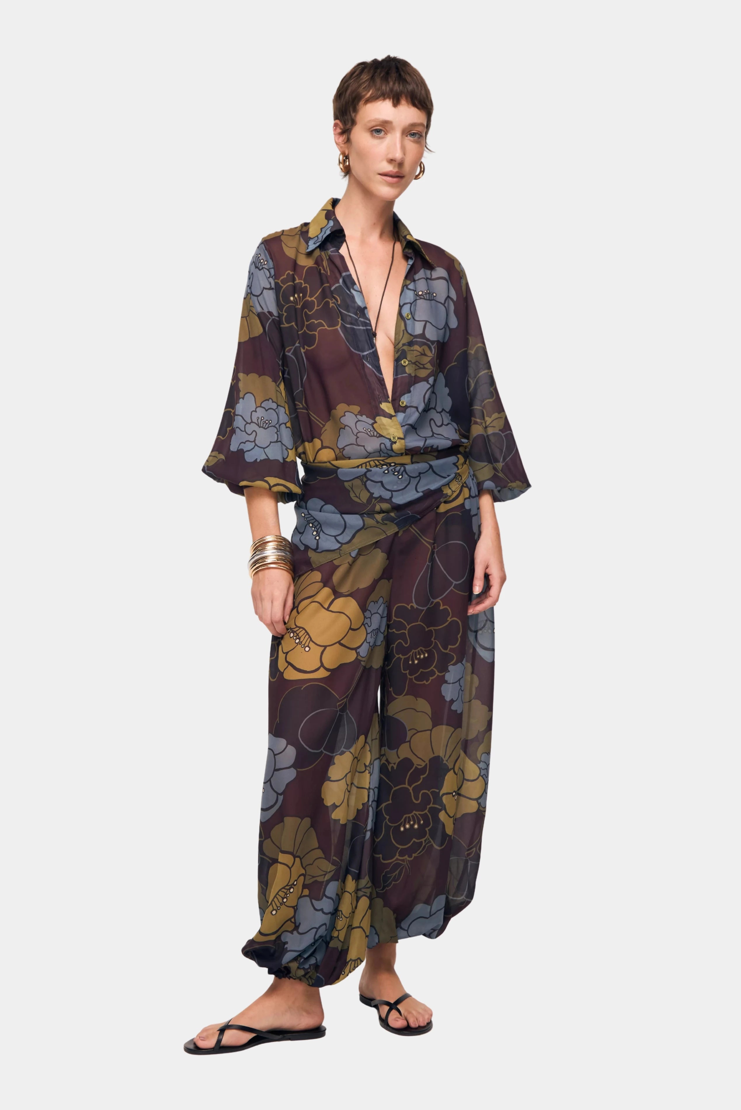 Calça Laiane Floral Bloom August com modelagem ampla e estampa floral em tons de azul e mostarda